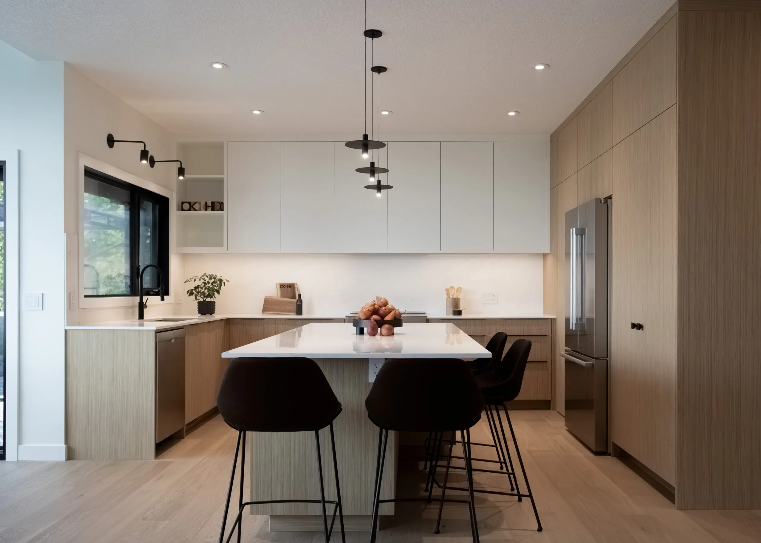 Image of  warm kitchen with dark island chairs and black accents.