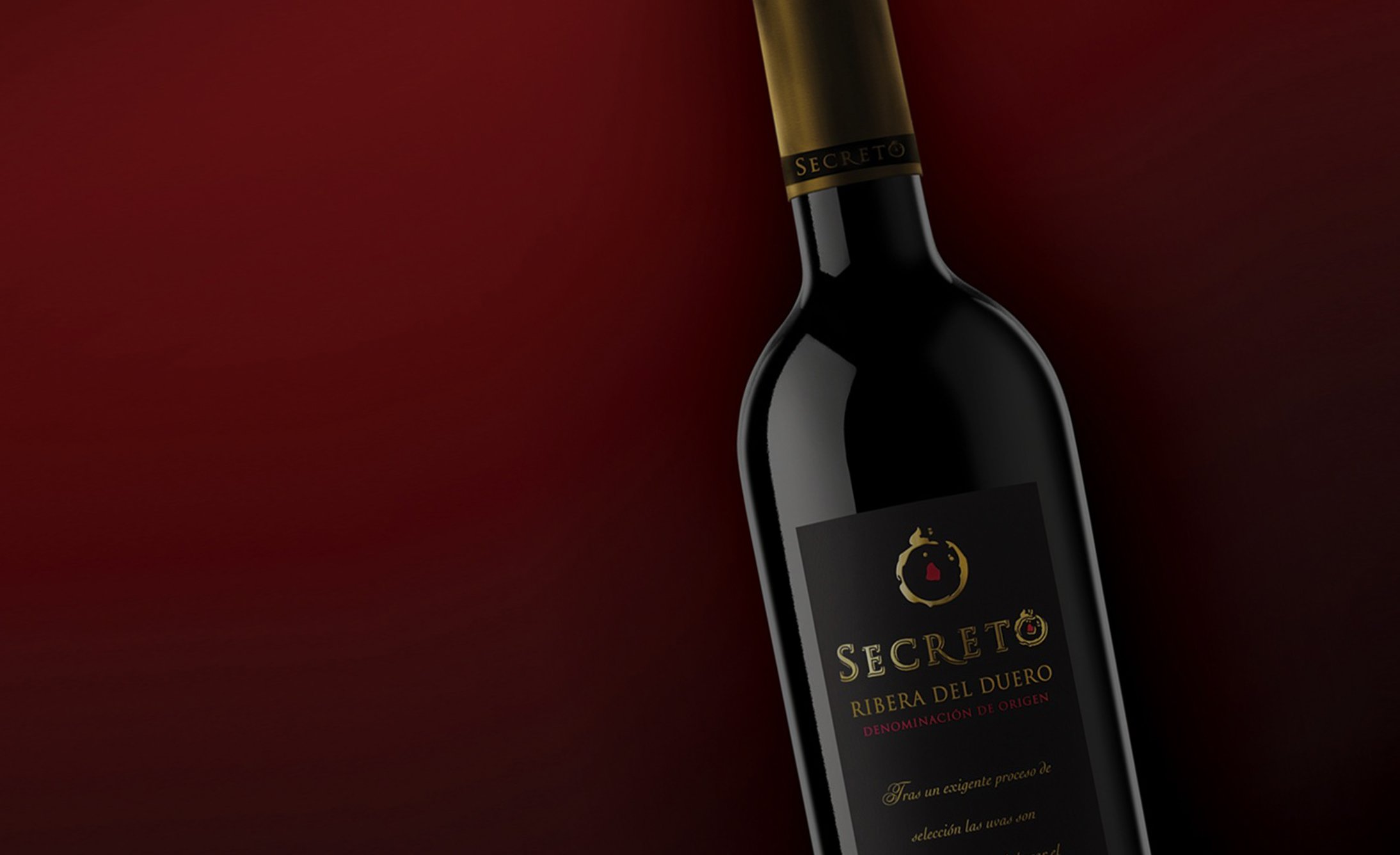 Una botella de vino tinto Secreto Ribera del Duero inclinada contra un fondo burdeos rico. La botella presenta un cuello dorado y una elegante etiqueta negra.