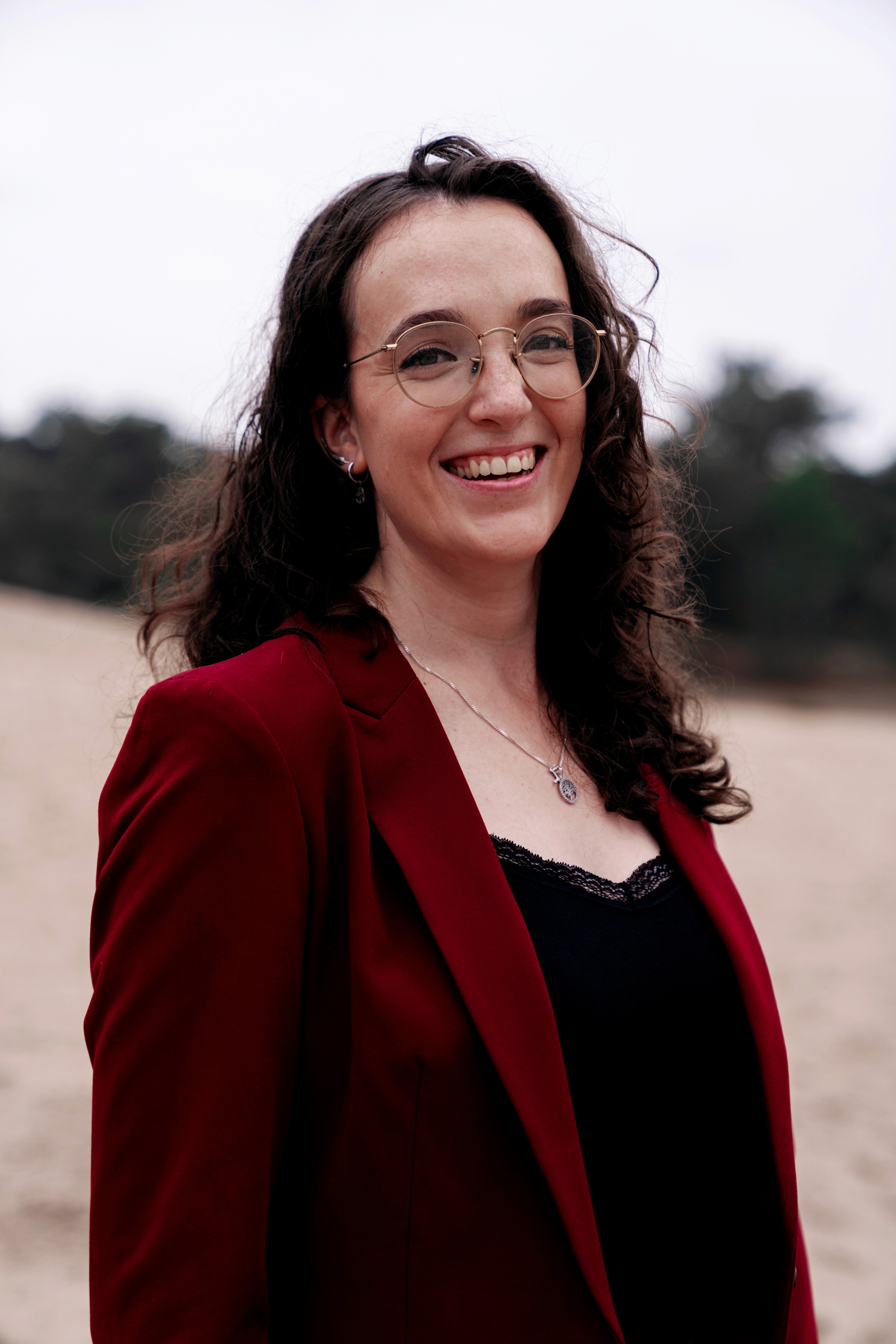Portrait of Sarah Mitchell, founder of Clarity, smiling in a navy blazer, seated indoors. Testimonial about gaining career clarity and direction after coaching.