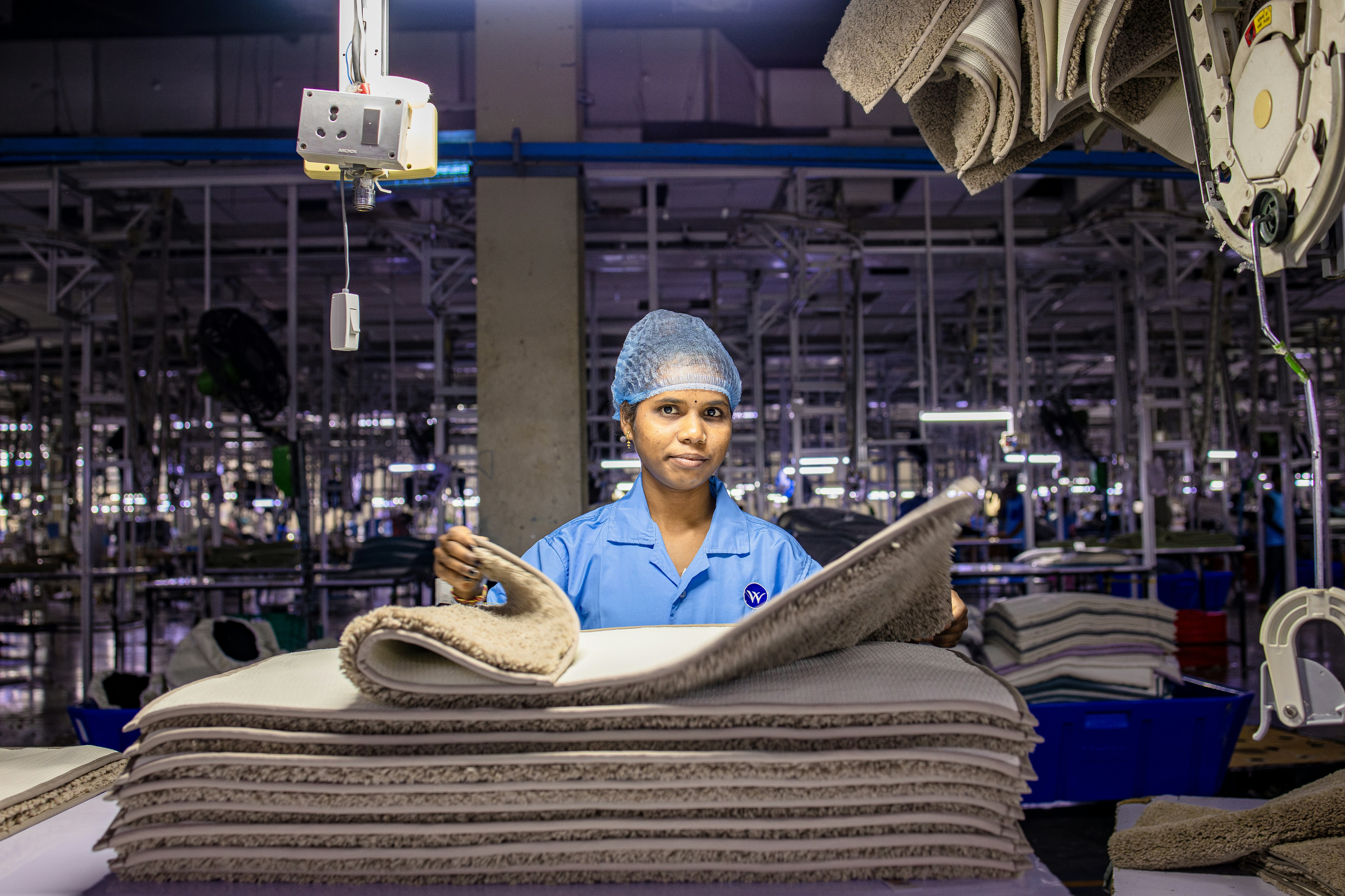 Woman works in a textile manufacturing facility.