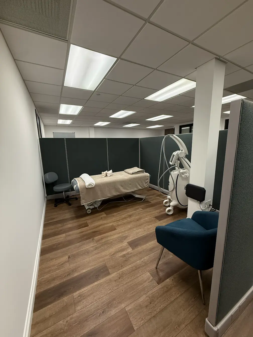 Massage treatment room with plush massage bed and ambient wall light