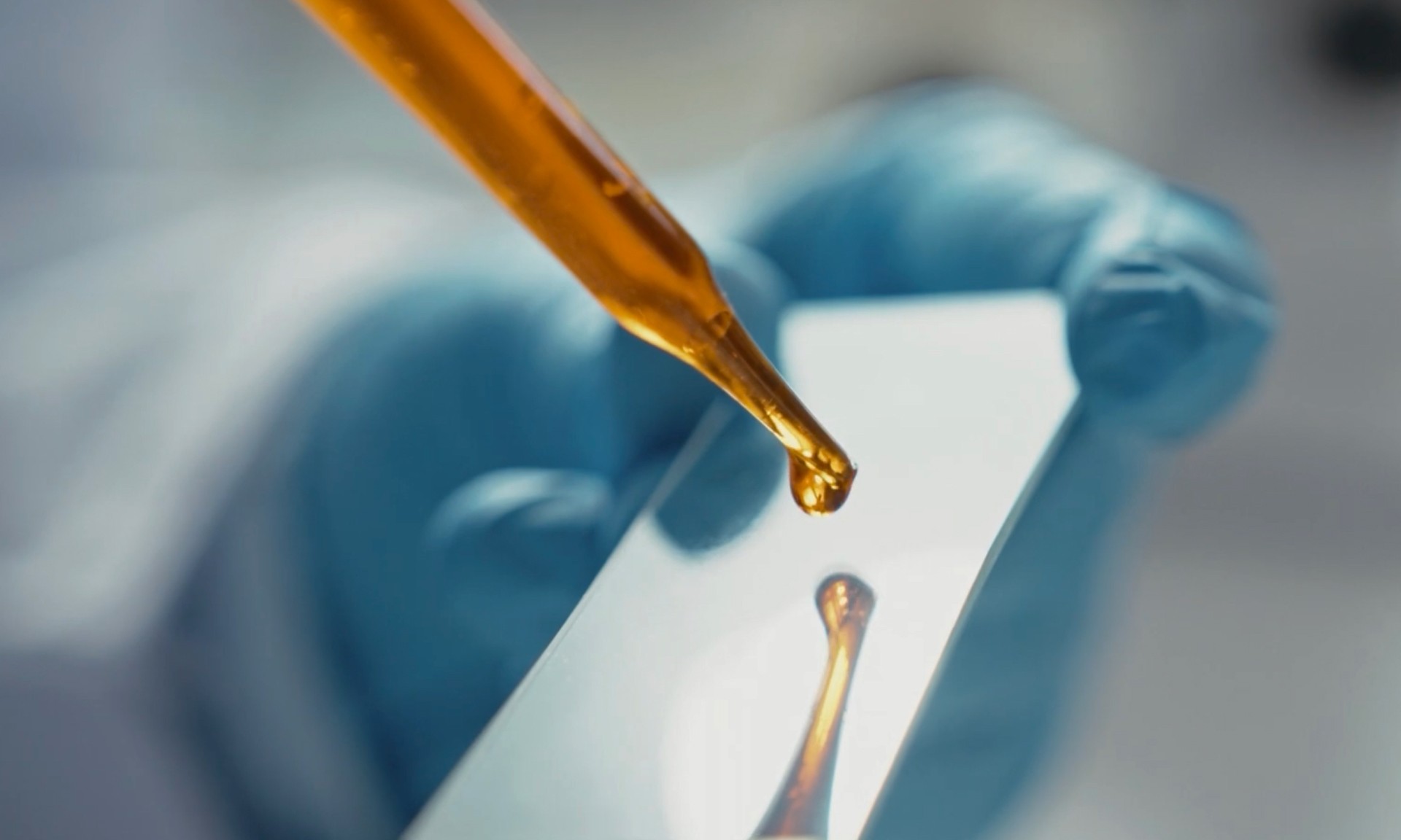 A close up photo of a liquid being dropped from a pipette