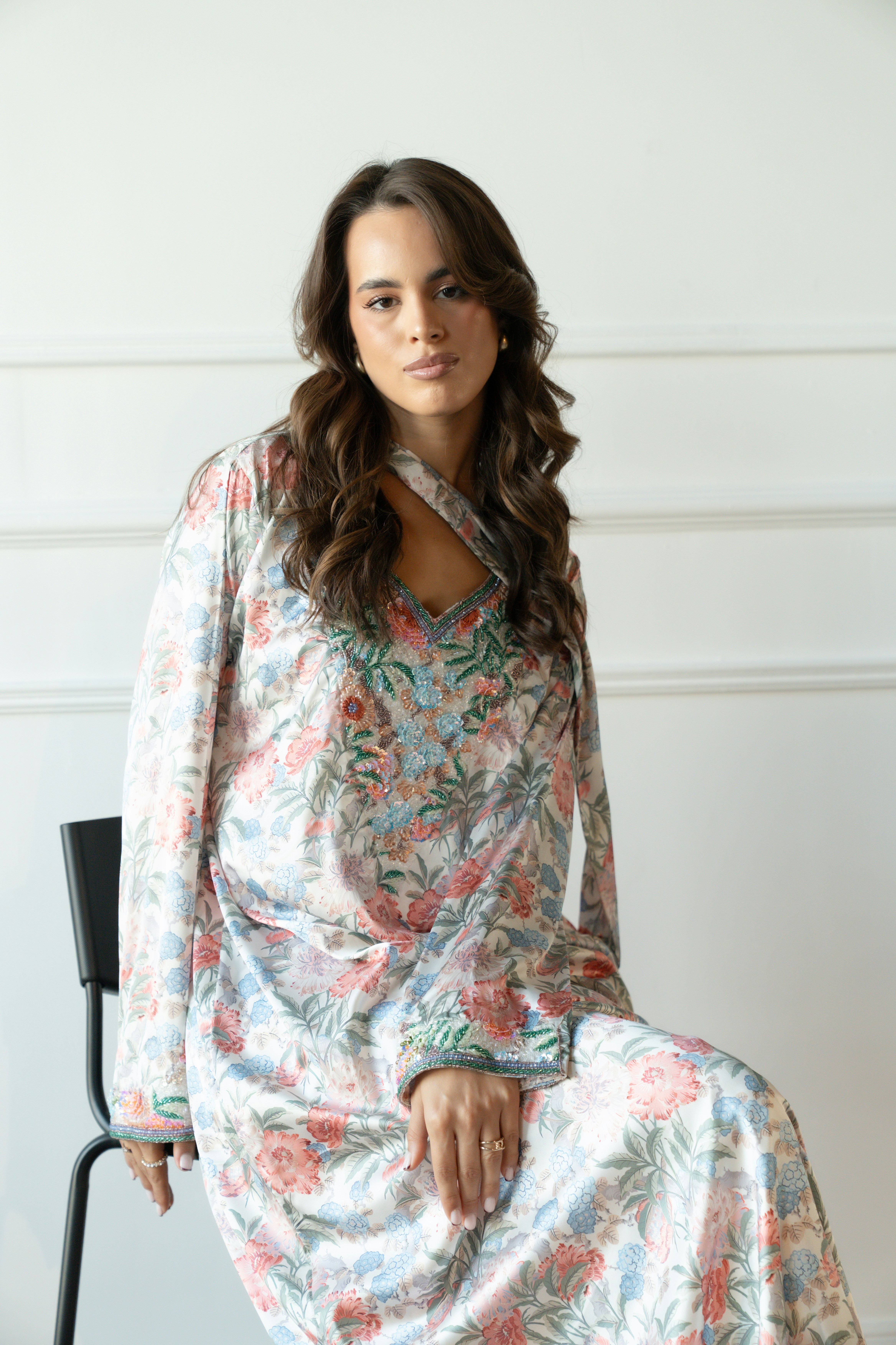 Woman wearing a floral print dress sitting on chair