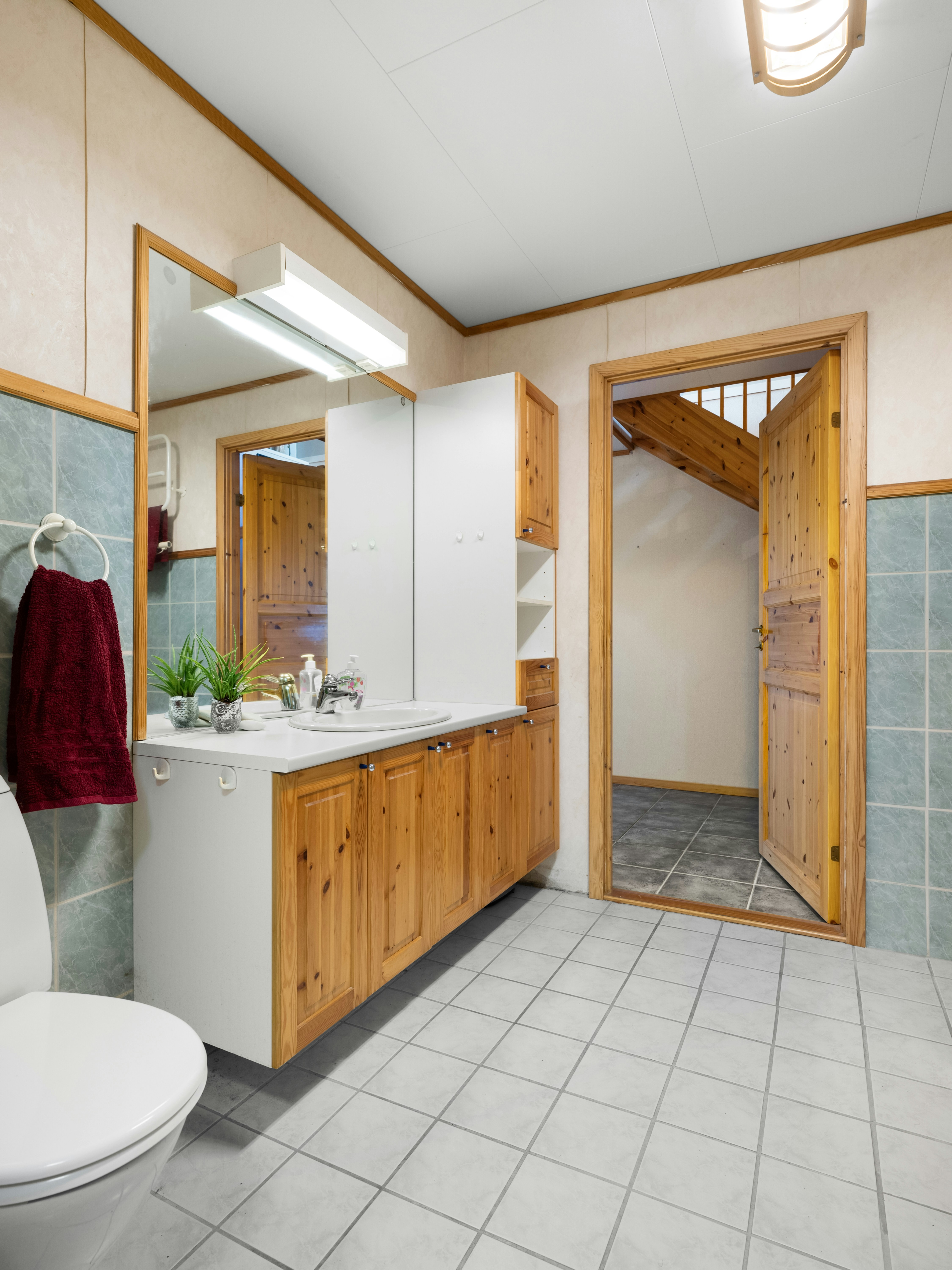 A bathroom with a toilet, sink, and mirror