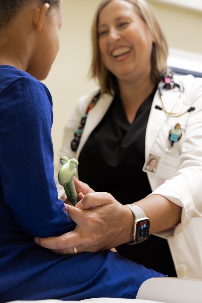 Pediatrician smiling toward young patient.