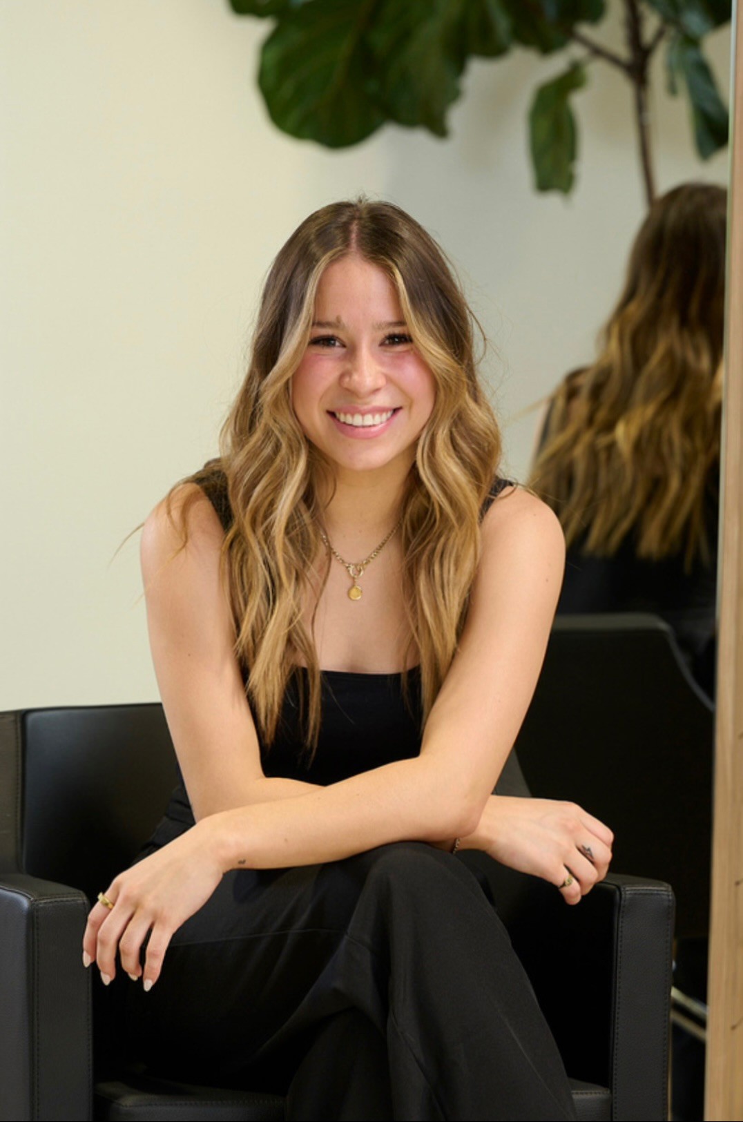 A woman lying down with a towel wrapped around her head, her face glistening with facial oil. Her eyes are closed, and she appears to be enjoying a spa treatment in a peaceful setting.