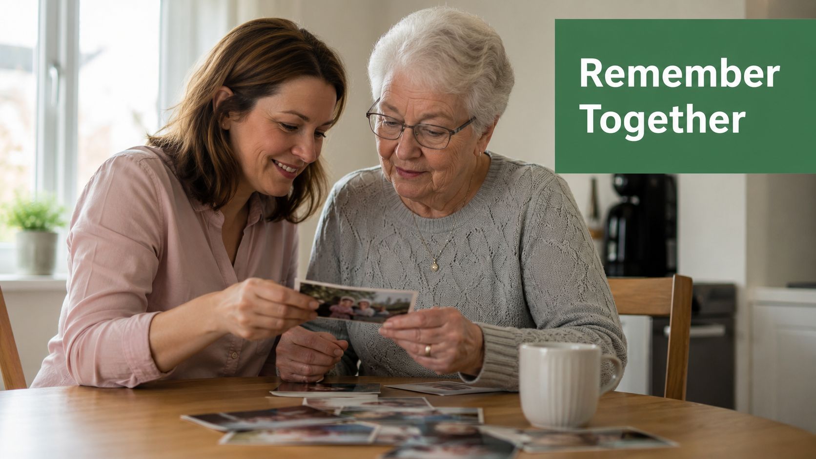 A woman helping an elderly senior look through old family photographs together at a wooden table.