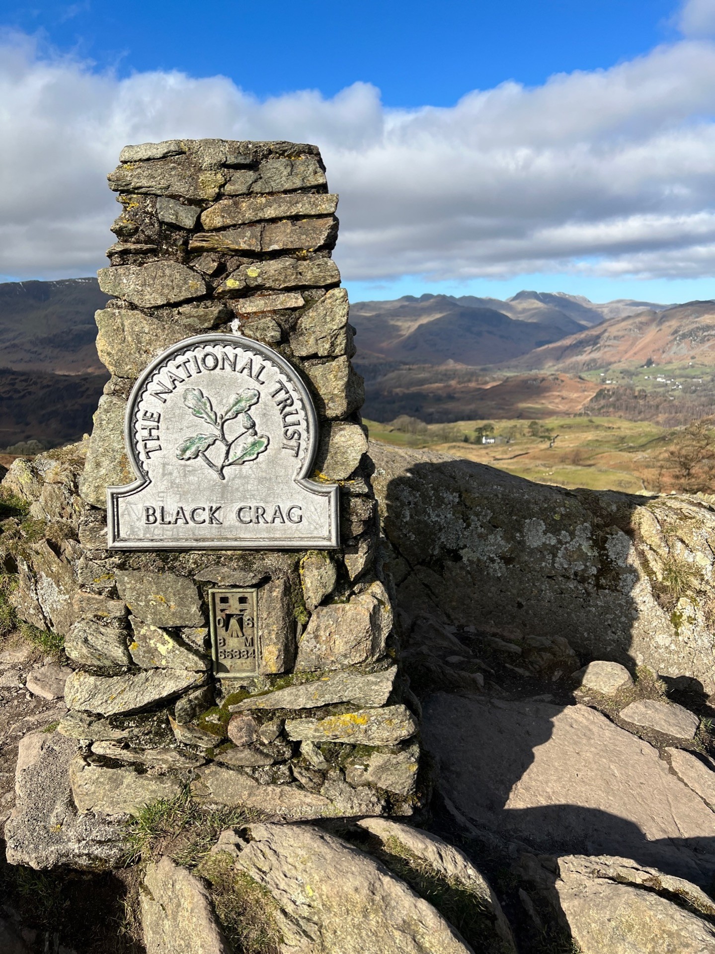 The Cairn atop Black Fell (the plaque actually reads Black Crag). Mountains in the backgrounds.