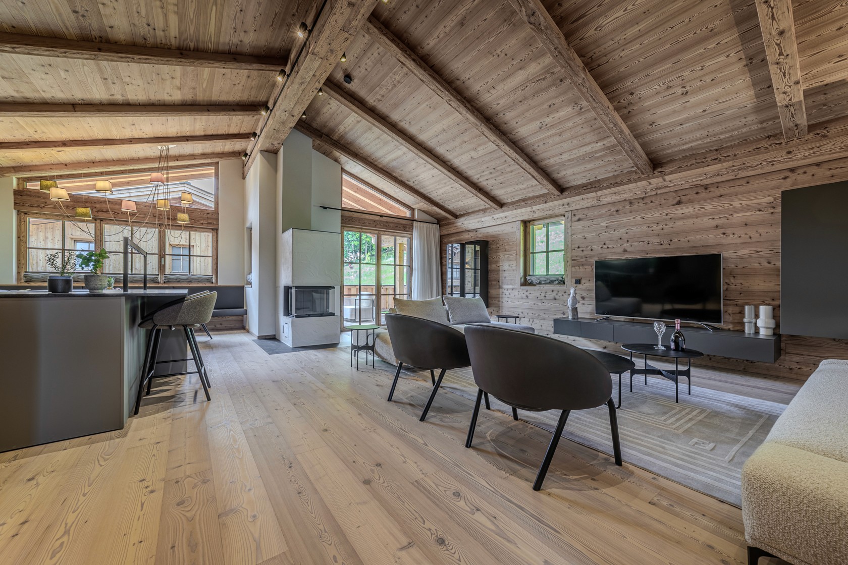 Offenes Wohnkonzept mit Holzelementen im Projekt Rettenstein – luxuriöses Wohnen im Herzen der Kitzbüheler Alpen.