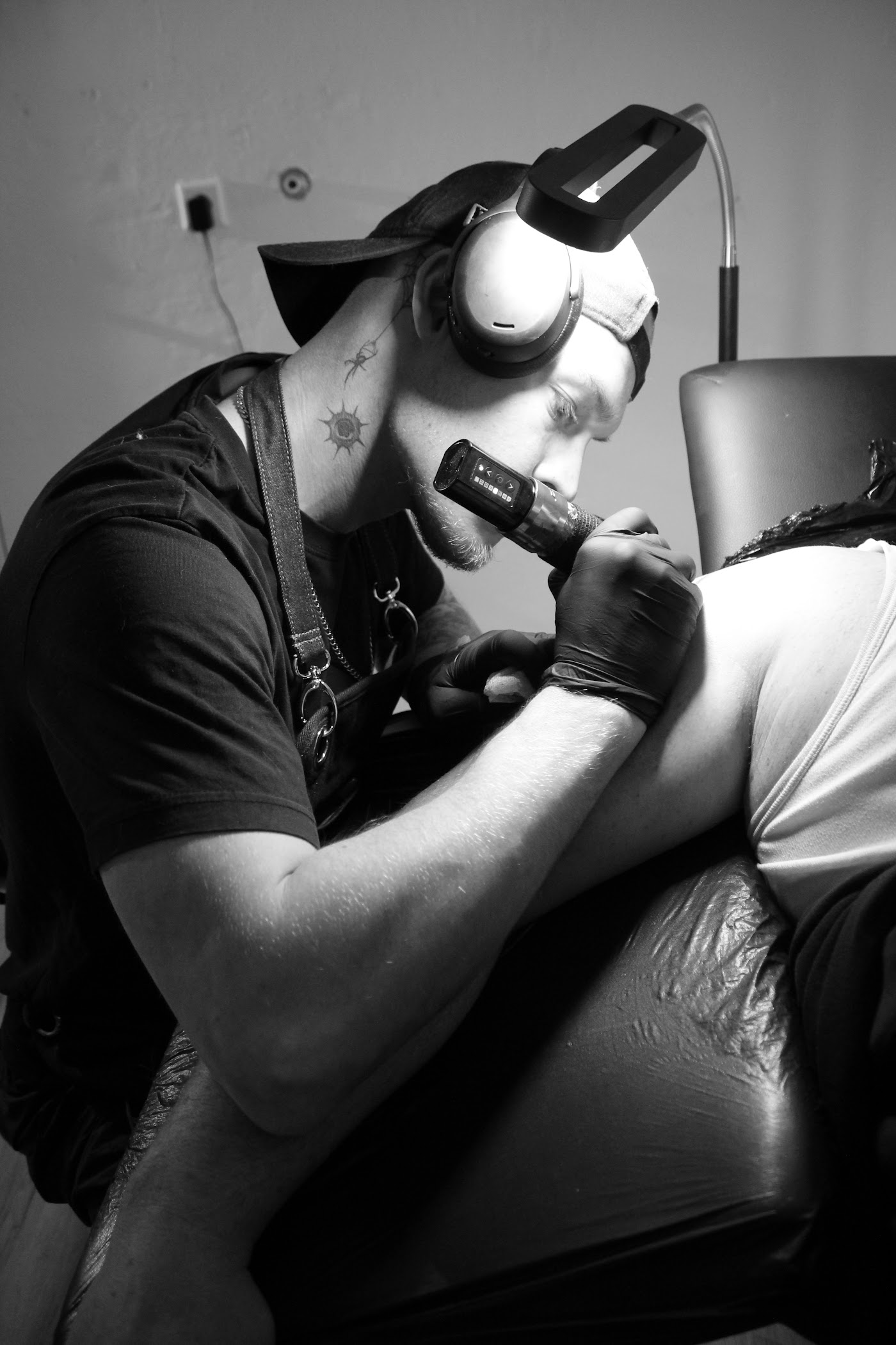 Nils Kordel bei der Arbeit am Tattoo, Schwarzweißaufnahme aus dem Studio