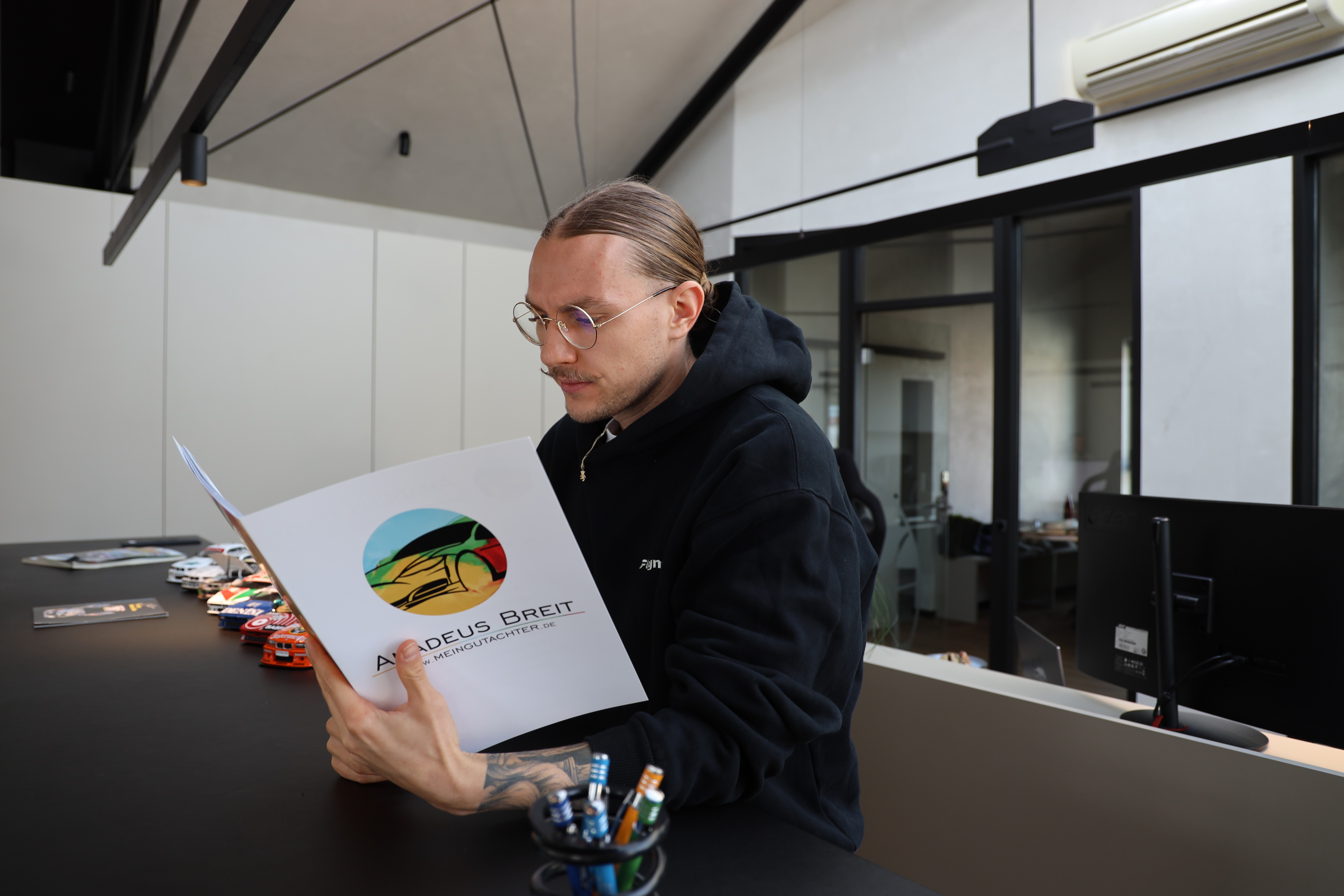 Amadeus Breit mit einem Unfallgutachten in der Hand, erstellt vom Büro in Homburg
