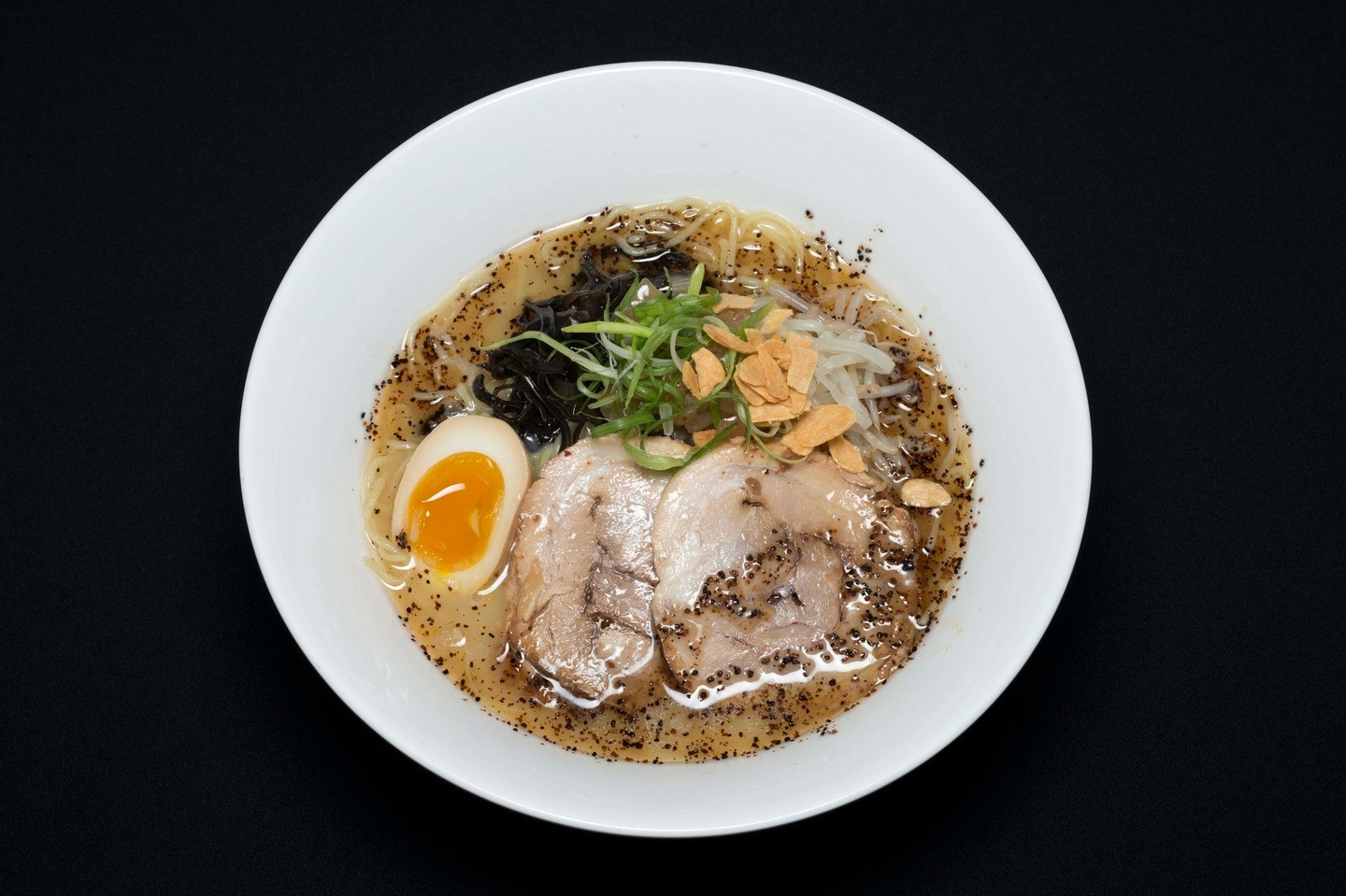 Close-up of a Toribashi ramen bowl on a dark background
