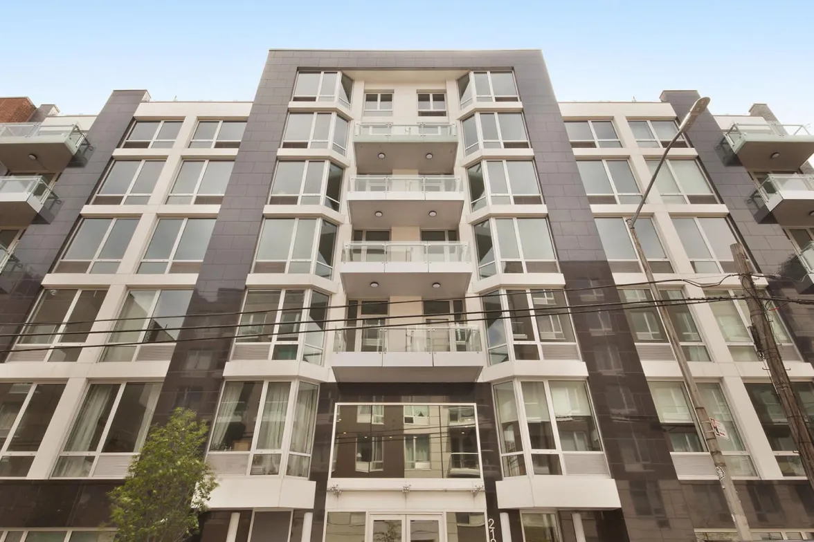 A large apartment building featuring numerous windows and balconies, showcasing a modern architectural design.