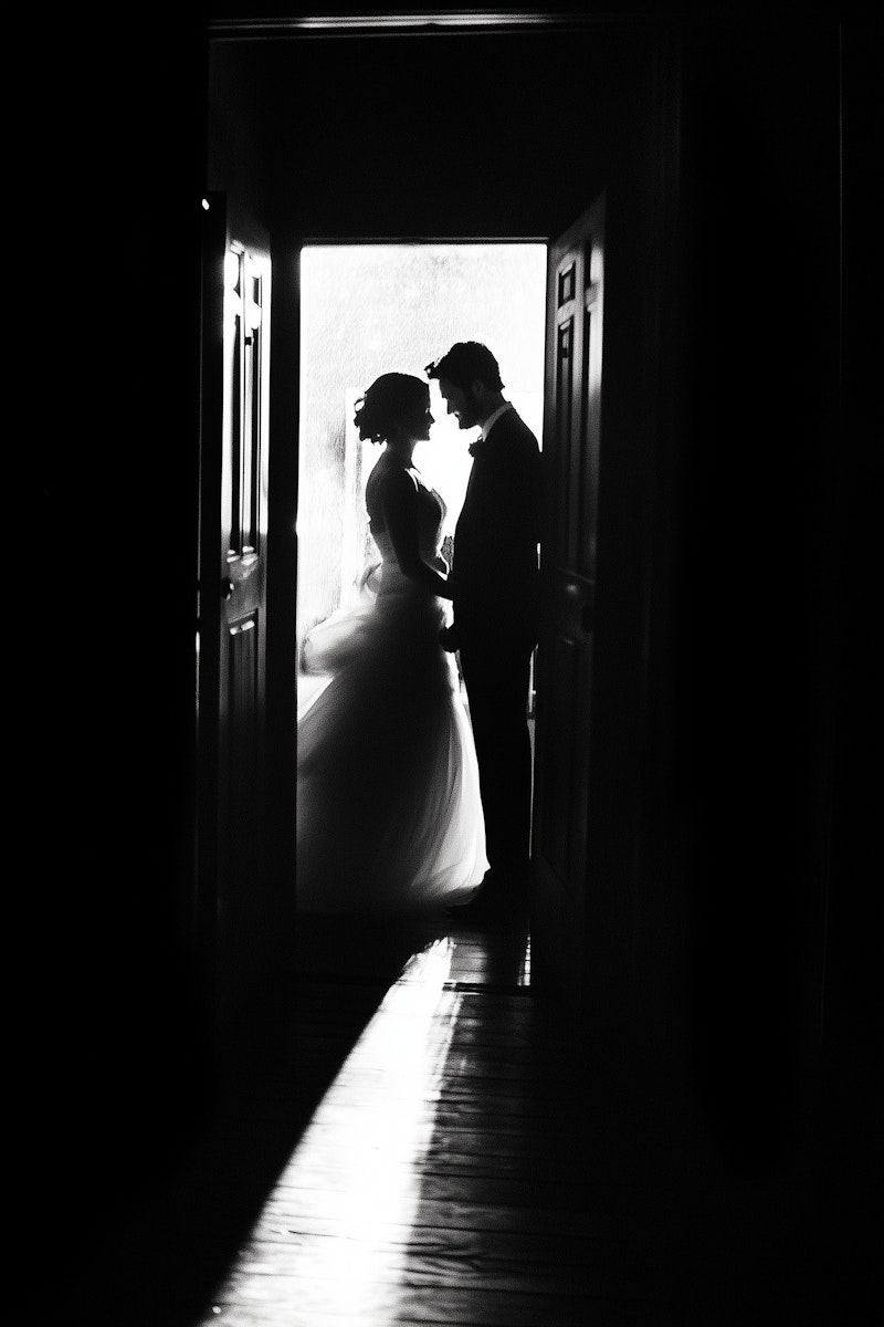 Romantic black and white silhouette of a couple in a doorway, creating an intimate and timeless scene.
