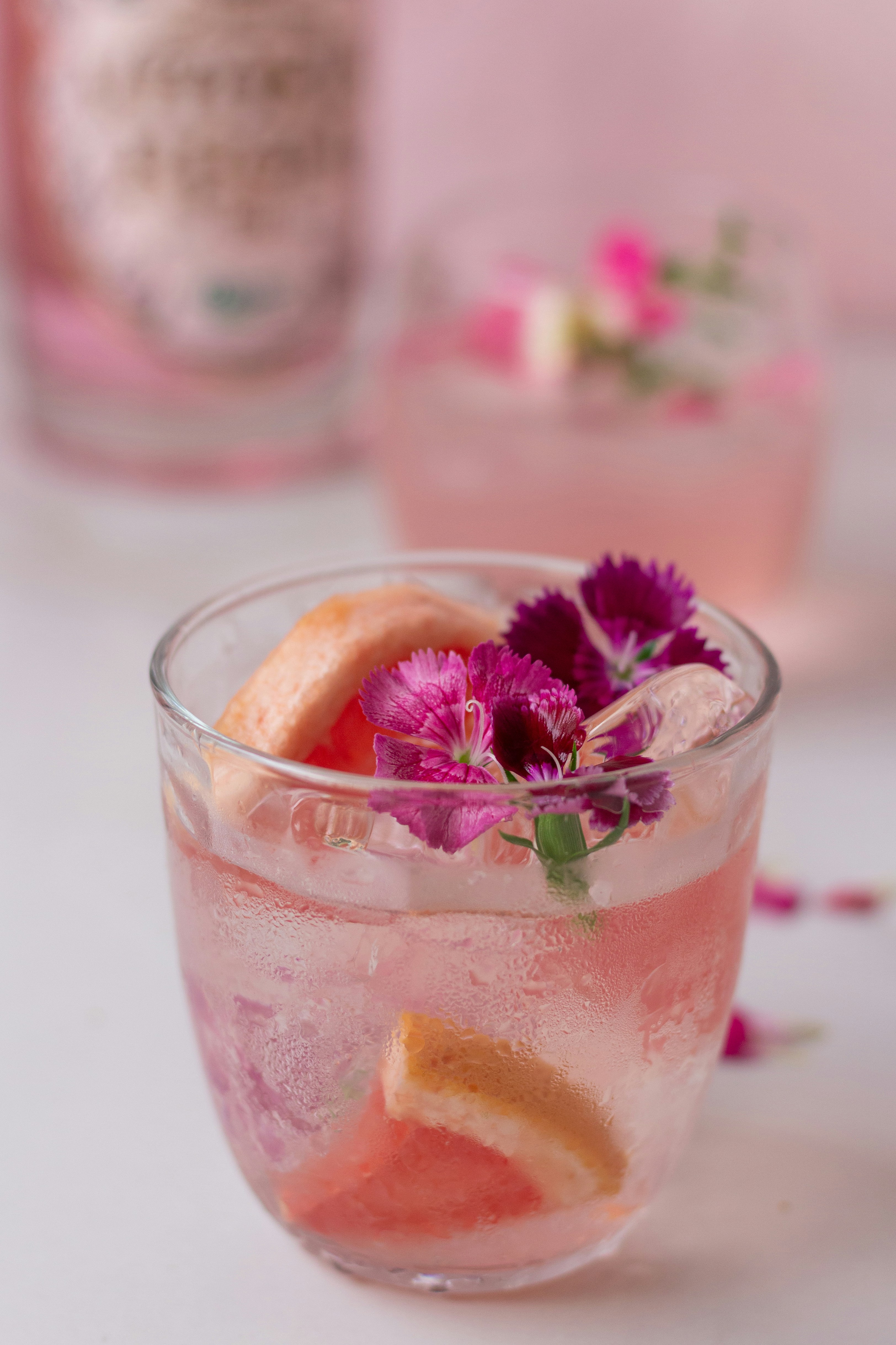 a glass filled with a drink and flowers