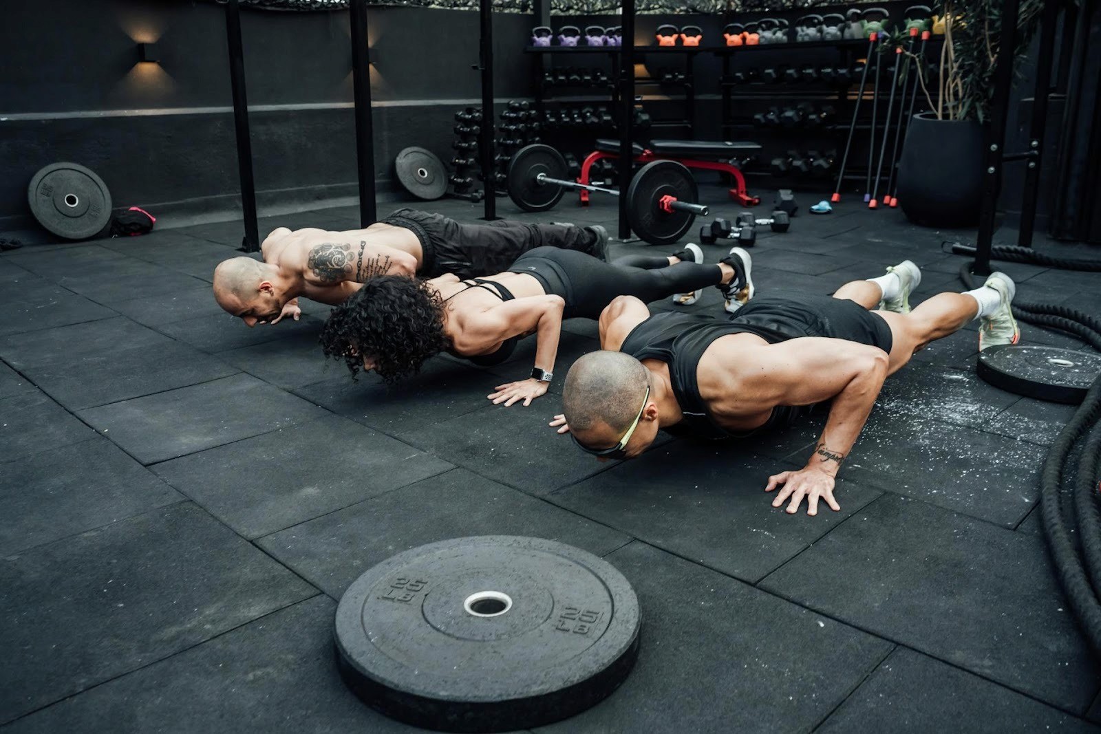 Group performing push-ups during an outdoor HIIT exercise routine.