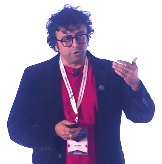 Man in turquoise headband and sunglasses looking straight at the camera. He is wearing red lenses in the glasses.