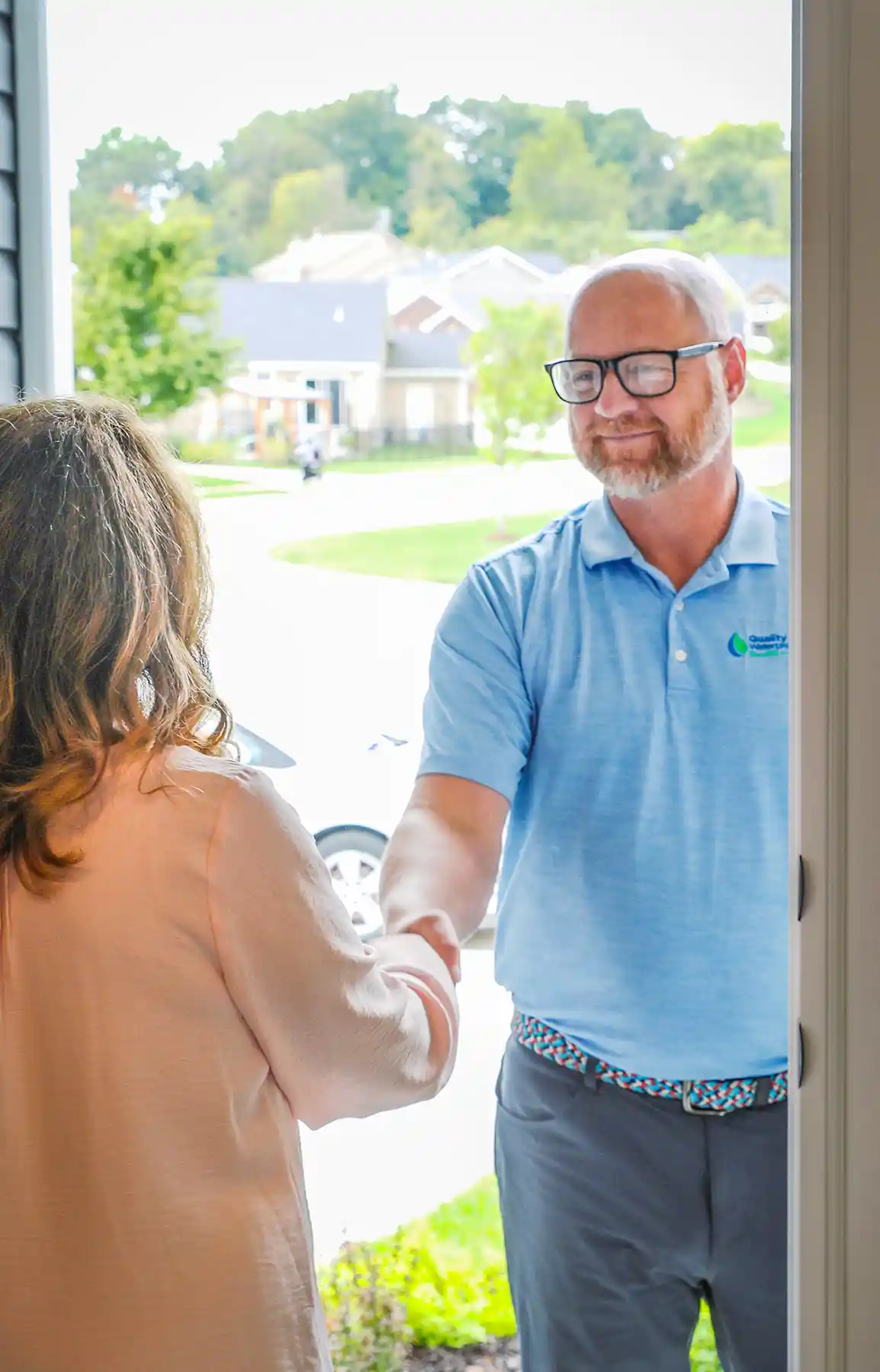 Photo of a home owner greeting a waterproofing inspector at the door