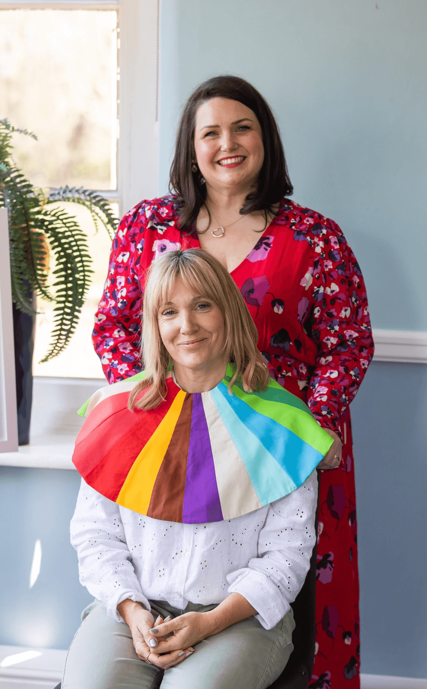 A smiling woman amid being draped.
