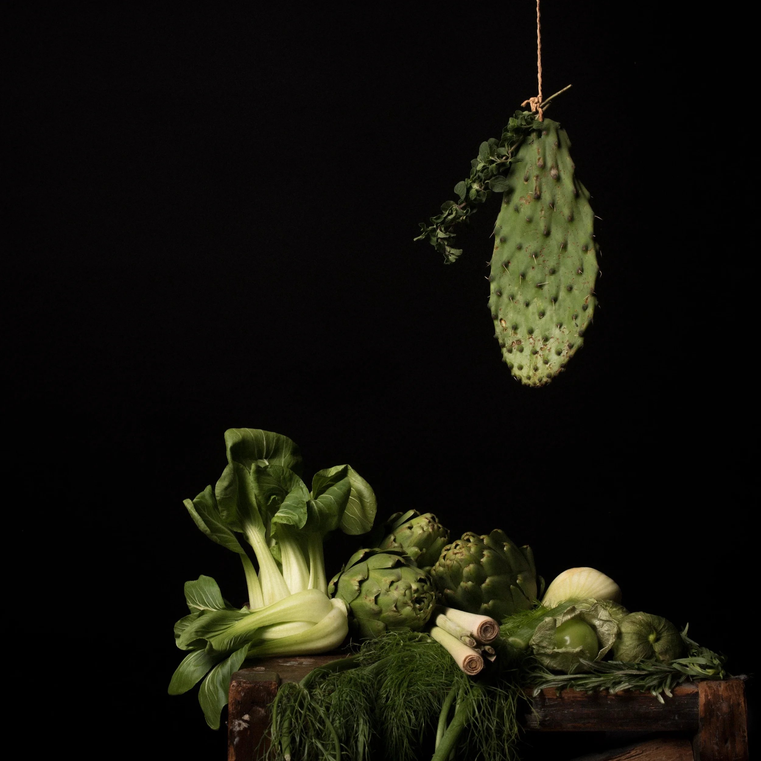 Arrangement of green vegetables set against a black background