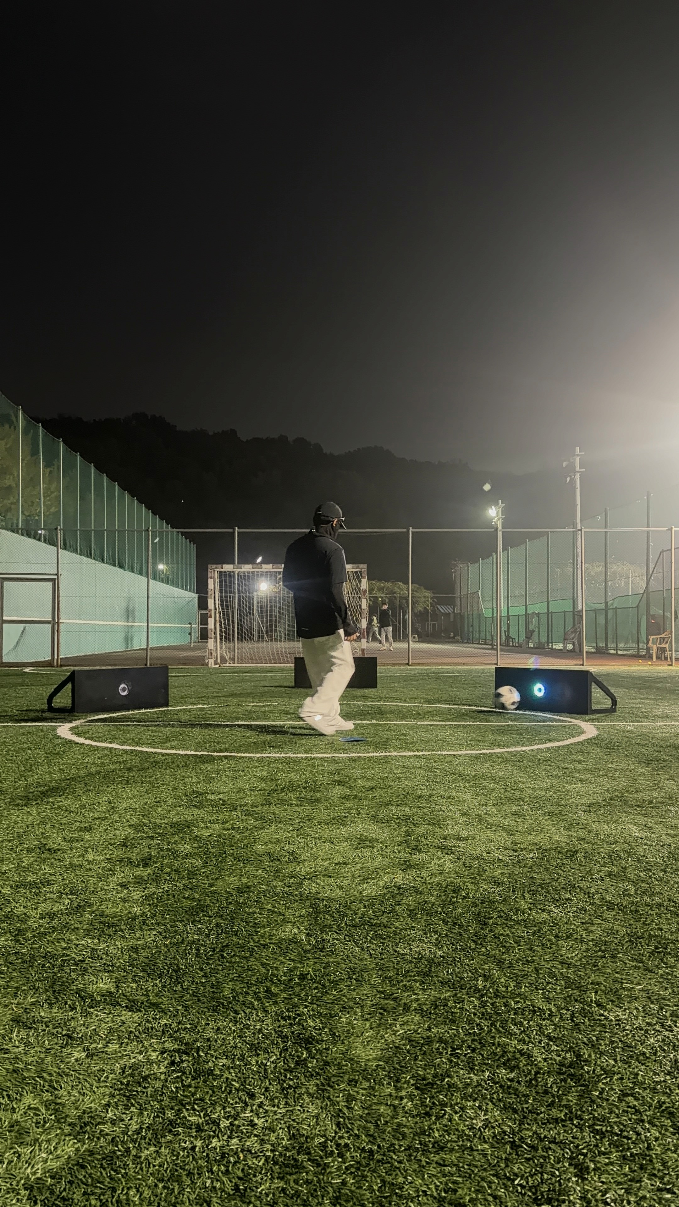 A group of men sitting next to each other holding soccer balls