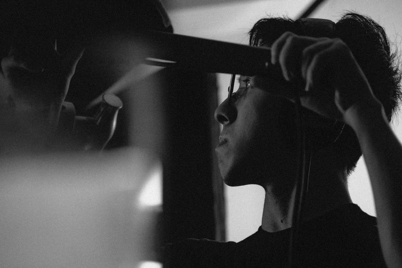 the boom operator holding thier boom pole to record sound properly