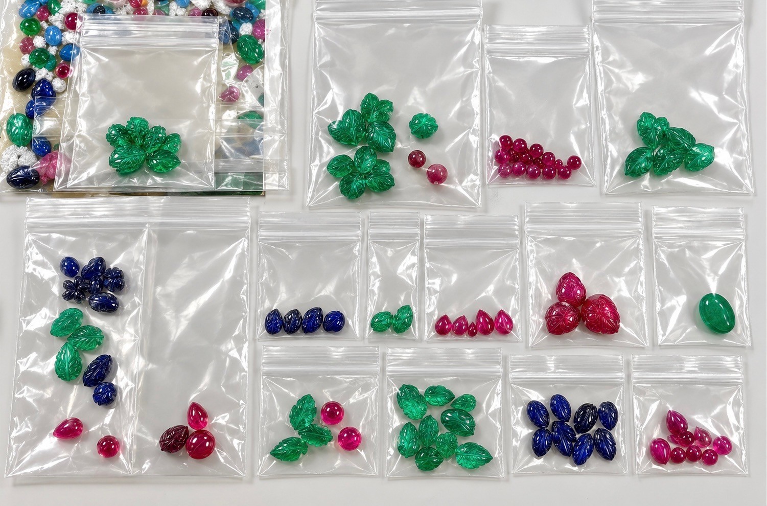 Custom cut lab-grown gems and carvings made to set in a necklace.