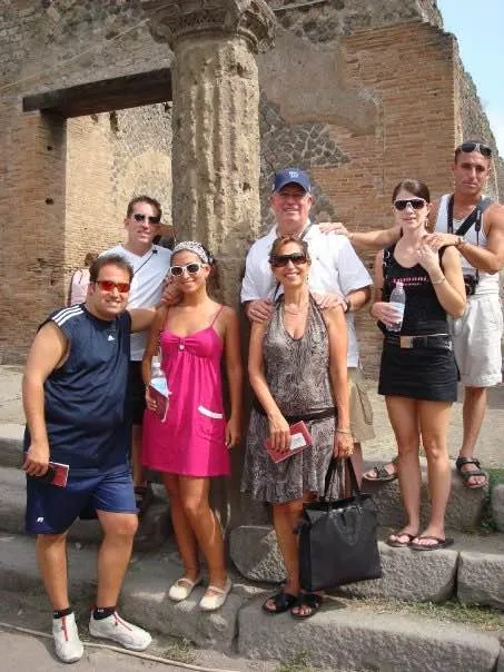 A group of travellers standing among the ancient columns at Pompeii.