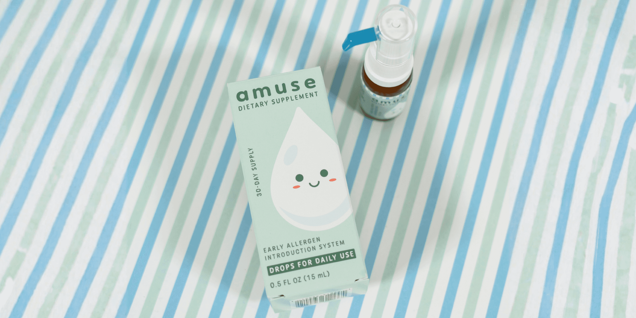 Amuse Drops product box and bottle displayed on a blue striped surface.