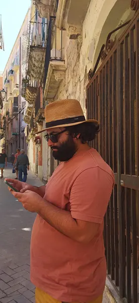 Foto di Claudio in Sicilia in una strada mentre legge indicazioni al telefono