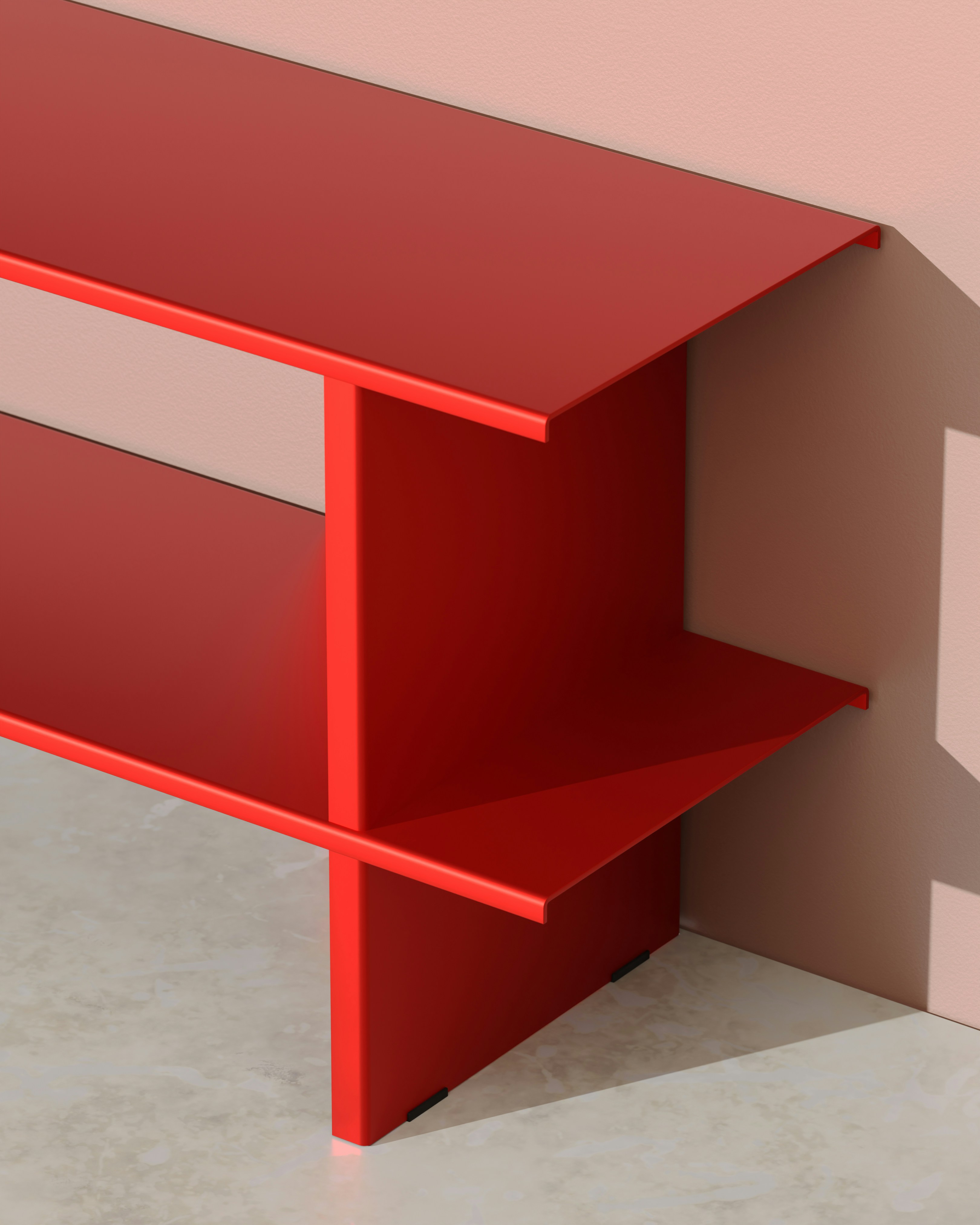 A red, geometric shelf sits against a wall.