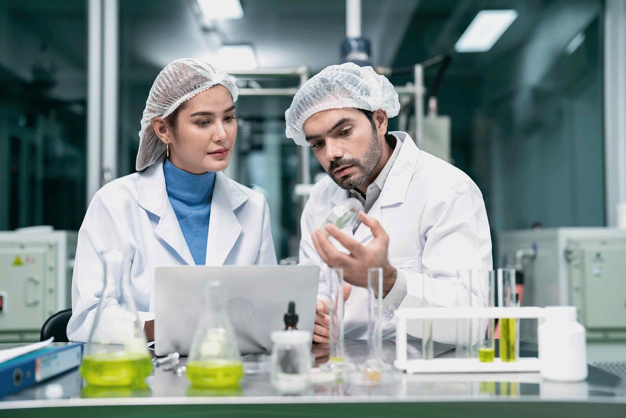 Two scientists examining a flask in a lab