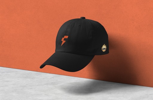 A black cap hovering against an orange wall, with part of a light-colored surface visible below.