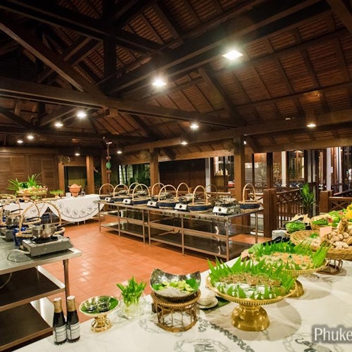Satu susunan bufet dalaman dengan pelbagai hidangan dipamerkan di bawah struktur bumbung kayu, menampilkan dulang hidangan yang berhias dan hiasan hijau.