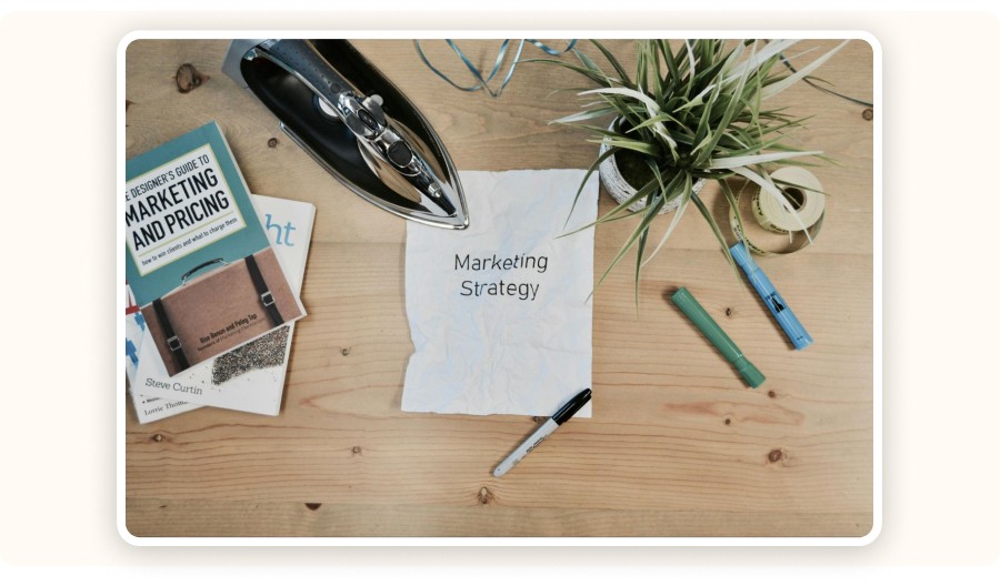 Livres et feuille intitulée Marketing Strategy illustrant les stratégies marketing enseignées dans la formation
