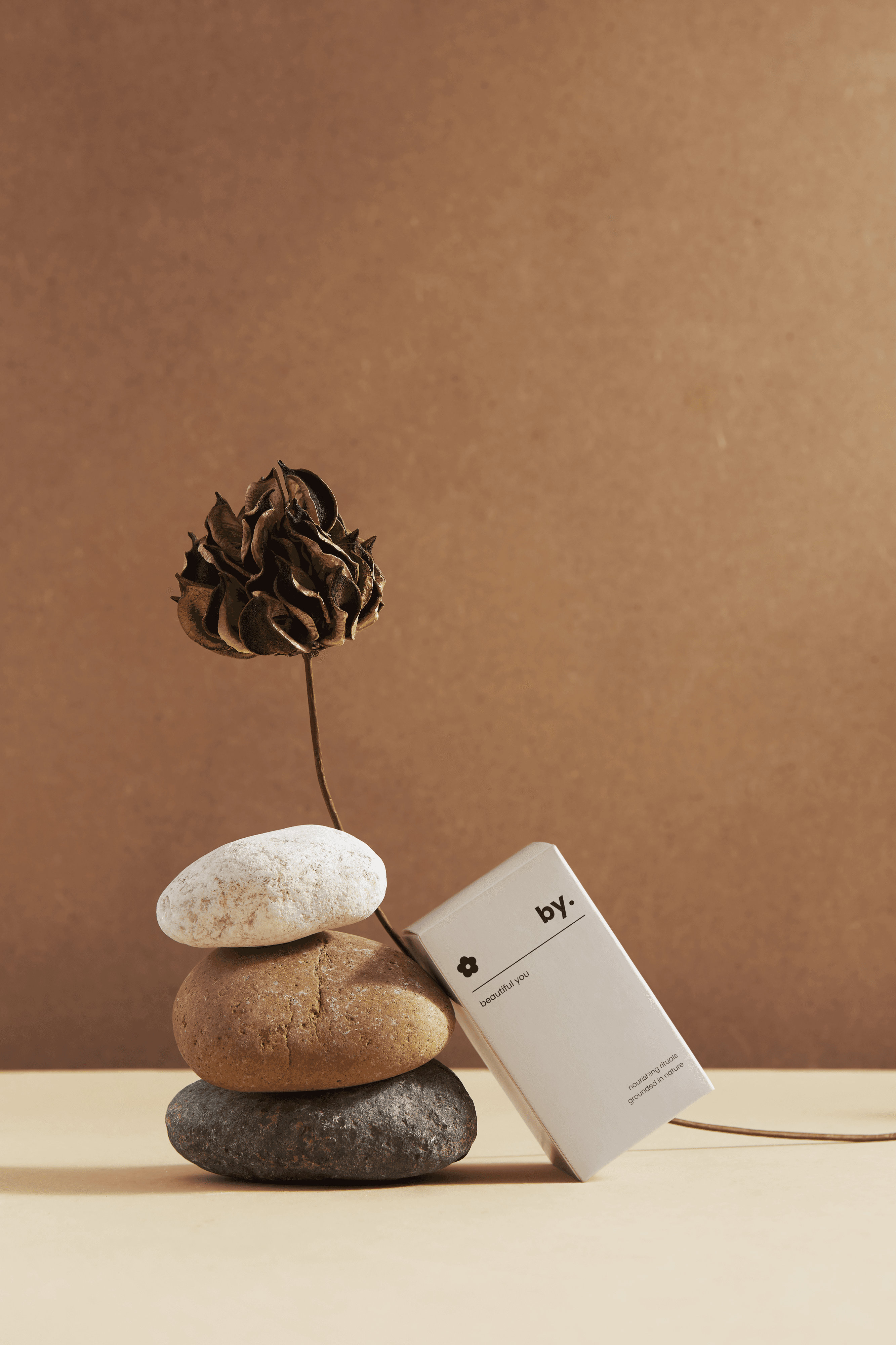 white skincare packaging staged against three rocks
