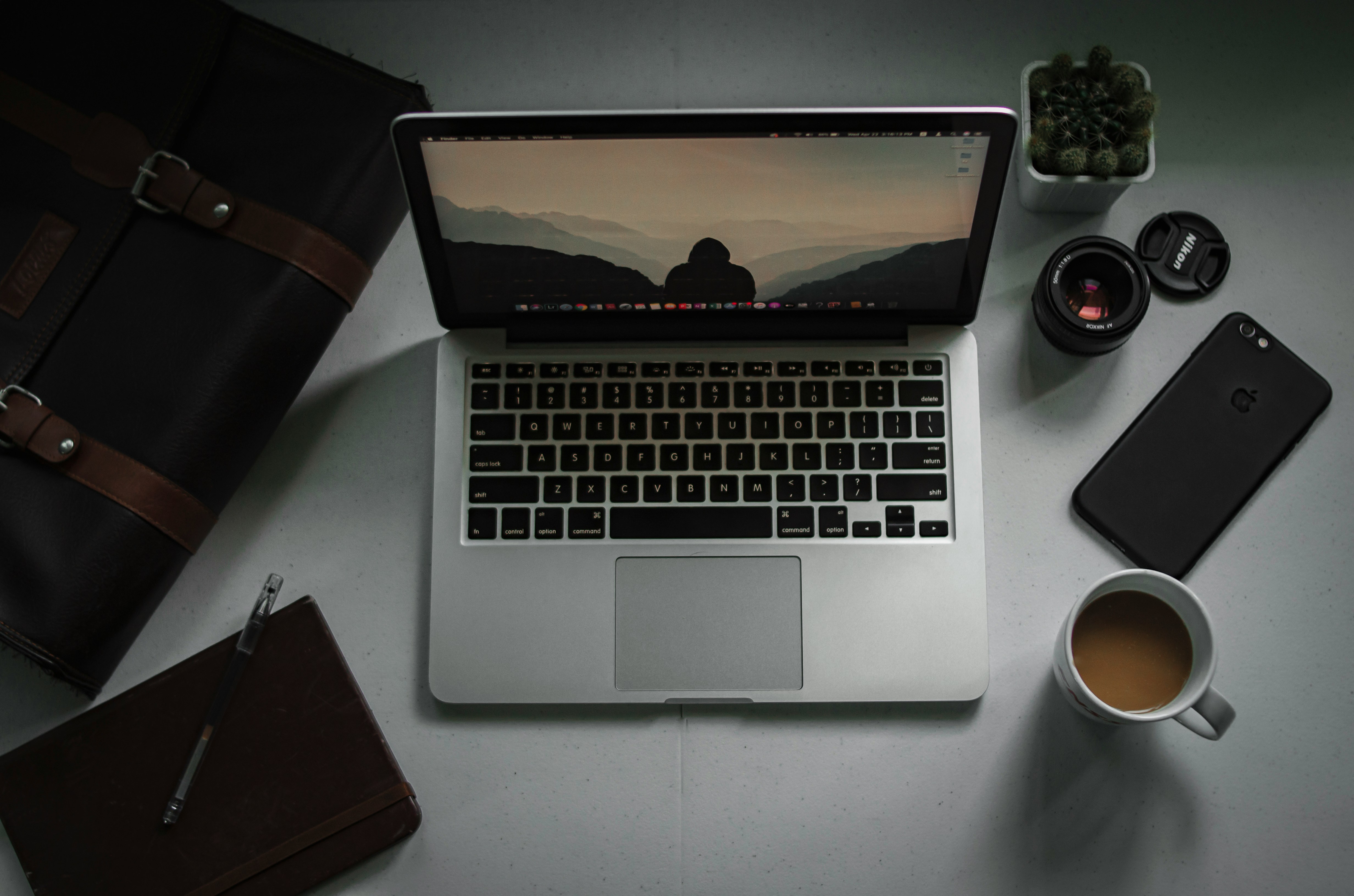 macbook pro beside brown leather wallet
