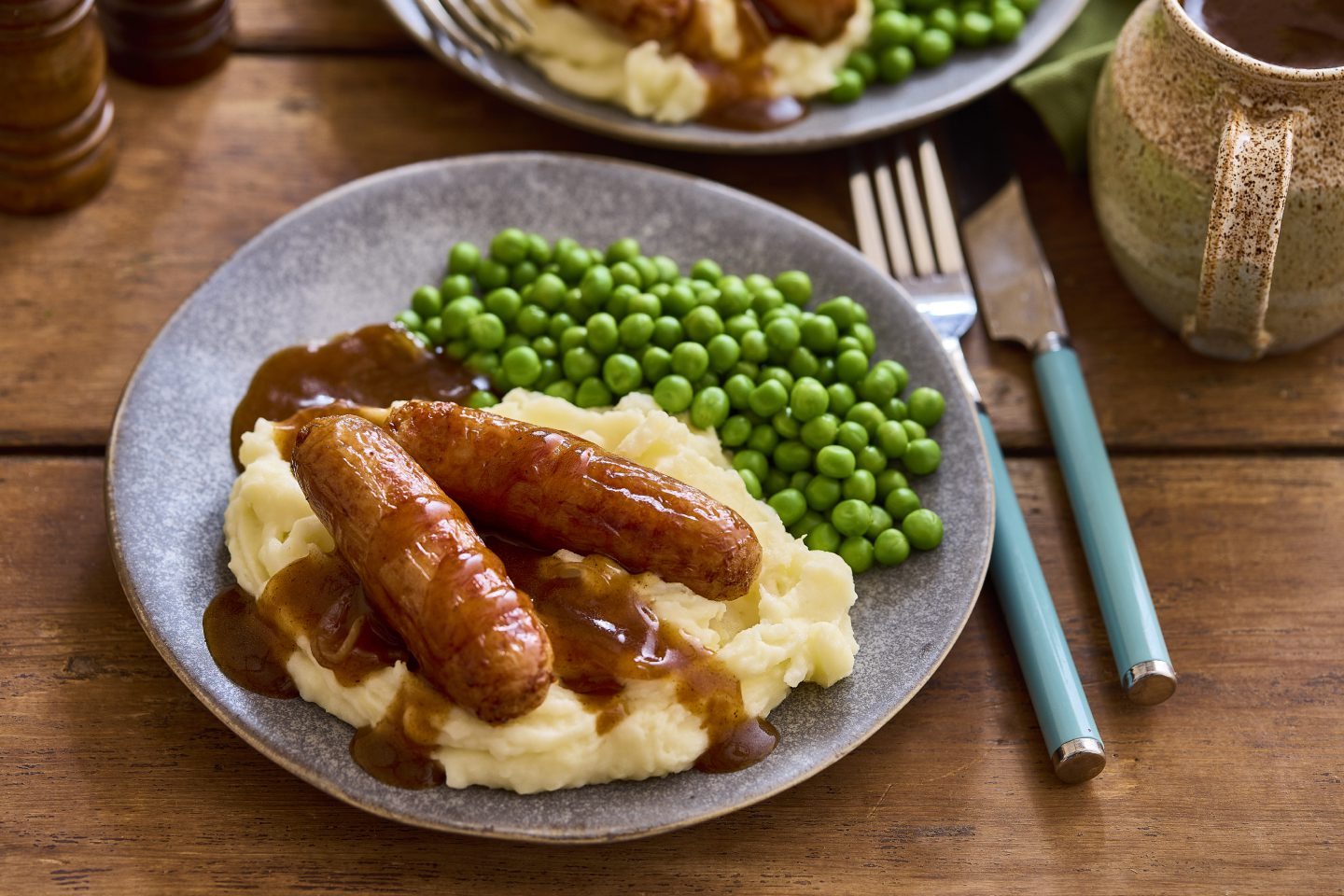 Cumberland sausage swirl served with creamy mashed potatoes, a rich onion gravy & garden peas