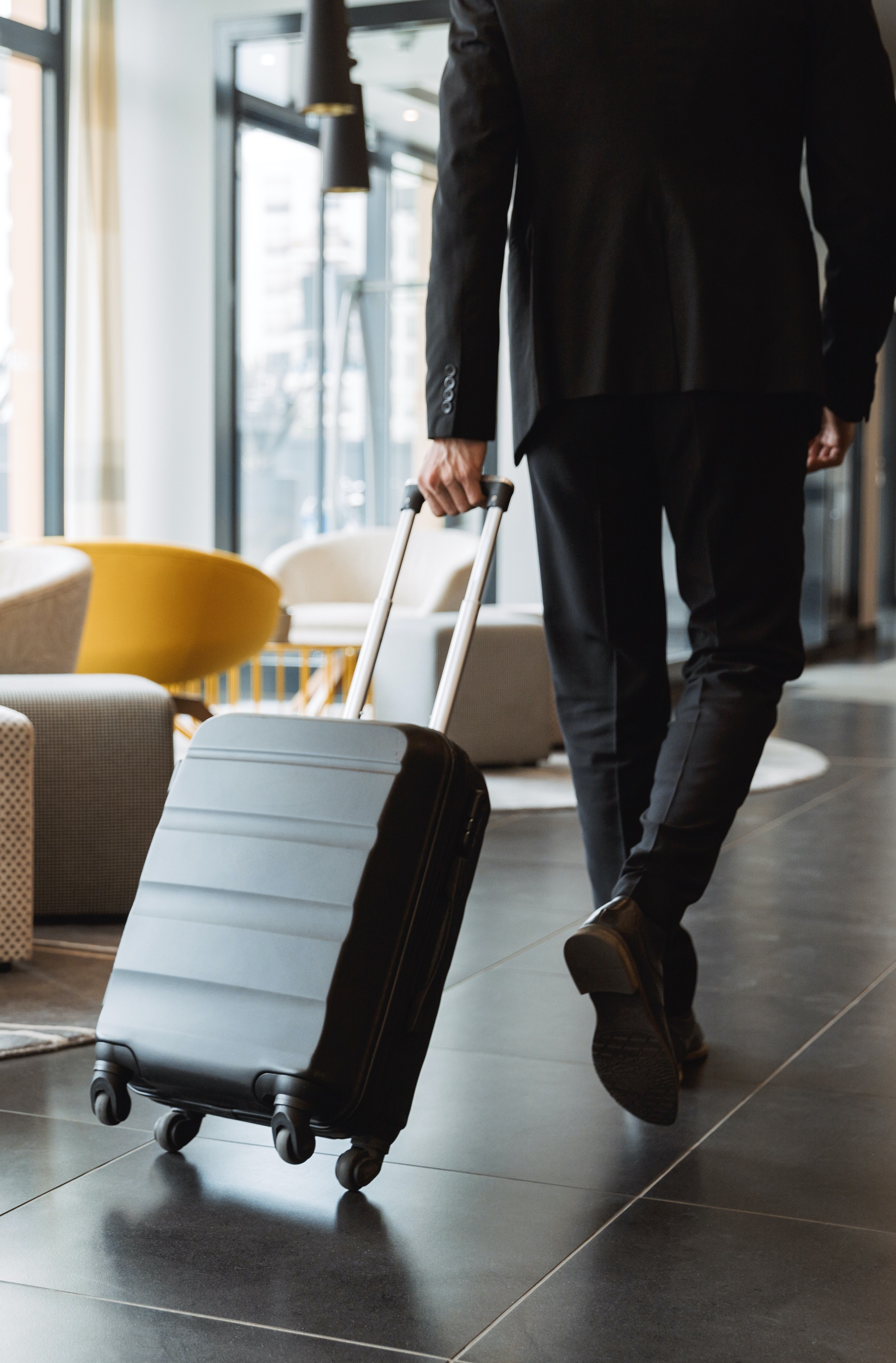 businessman in a suit with a suitcase in town entering a hotel lobby