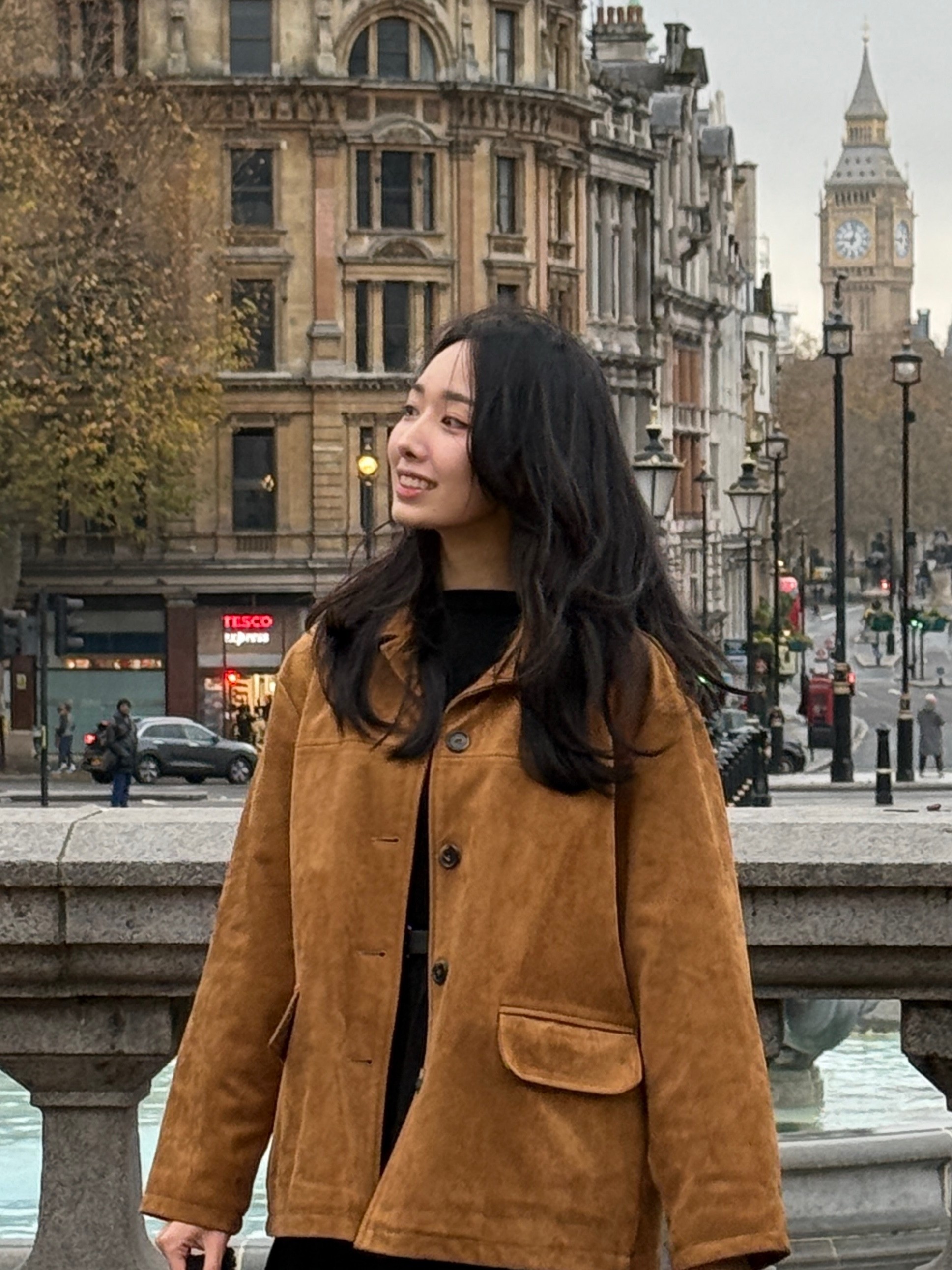 Portrait of a laughing person with curly hair wearing a white shirt