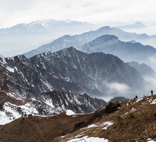 A layered view of a snow-dusted mountain range