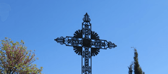 Croix en fer forgé à Arboras, sur fond de ciel bleu
