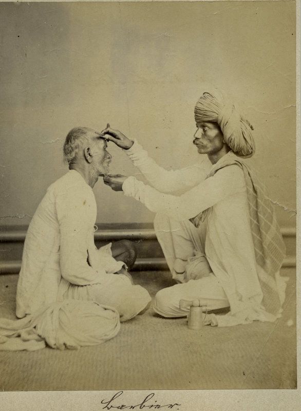 A person with curly hair sits at a desk, working on a laptop in a cozy, well-lit environment.
