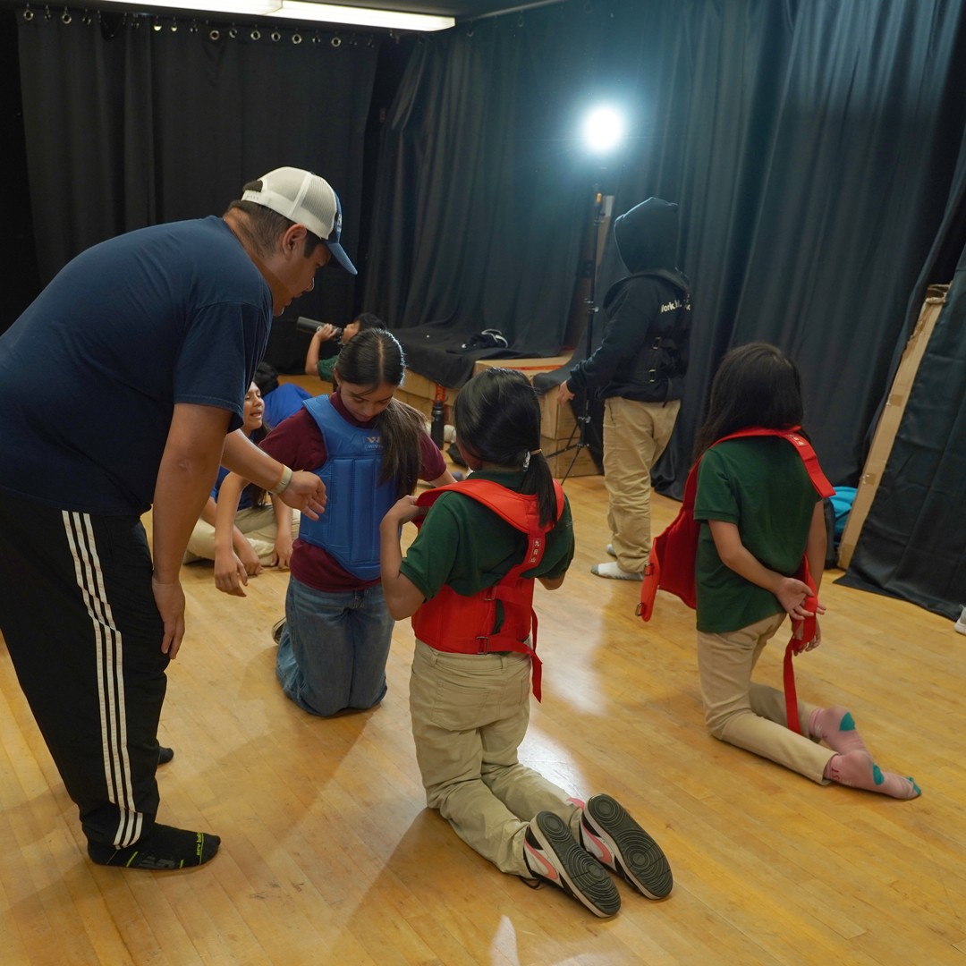 Students performing basic karate stances and kicks in school-based martial arts program