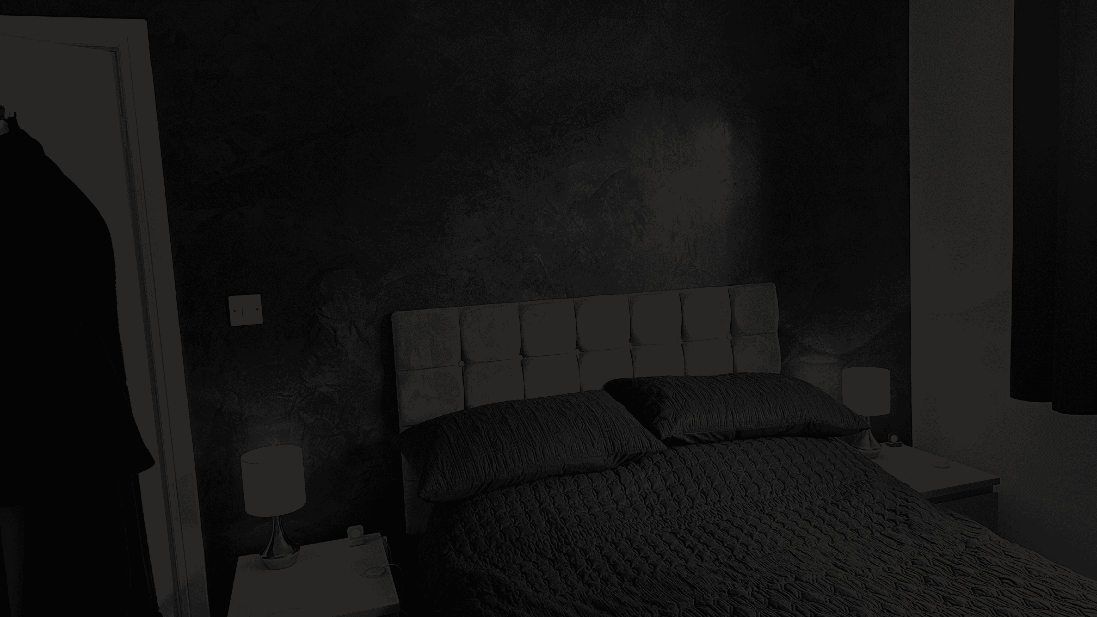 Bedroom wall showing black venetian plaster.