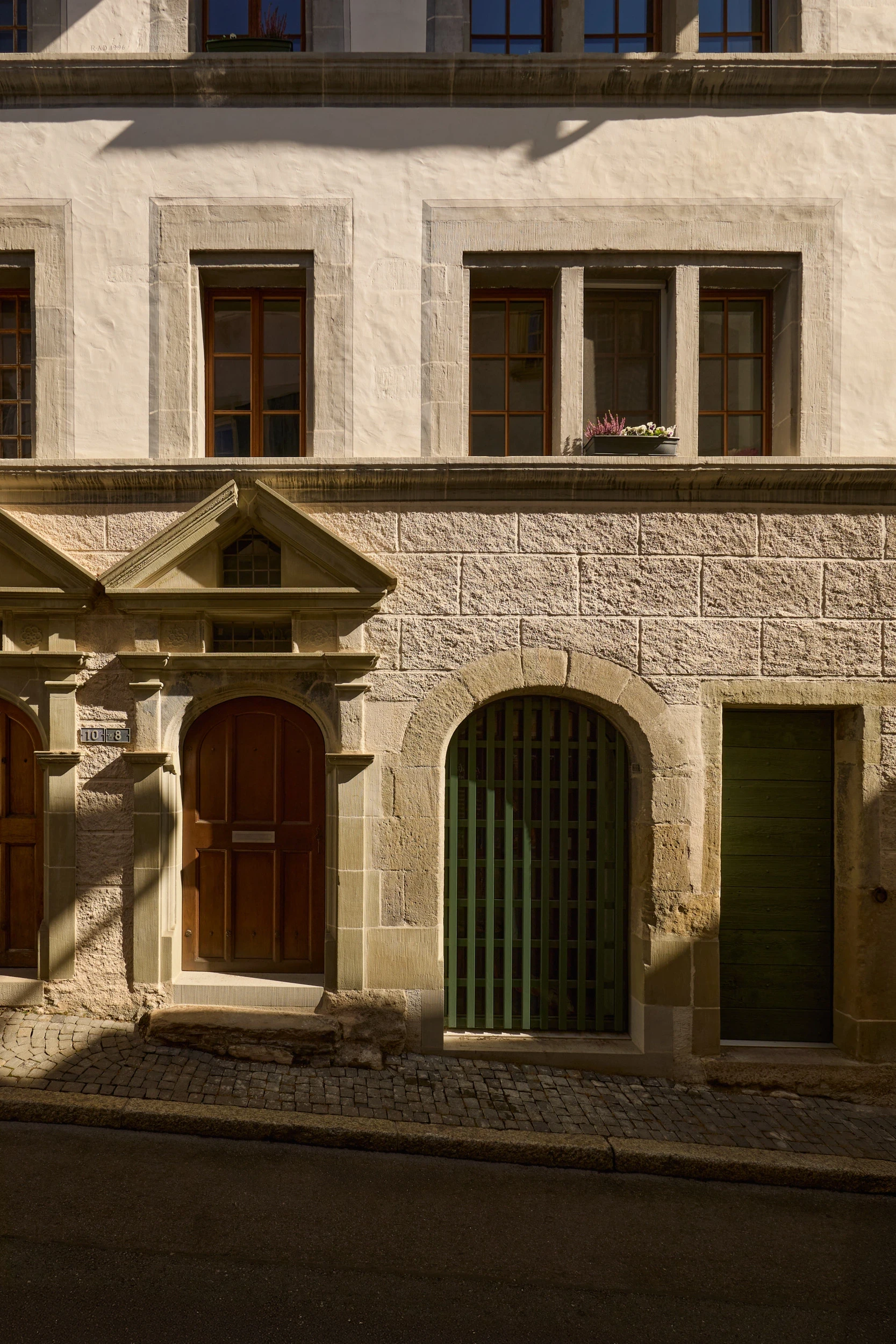 Détail de la façade historique de la maison Muriset à Cully, dans le Lavaux classé UNESCO, avec menuiseries contemporaines intégrées au bâti ancien.