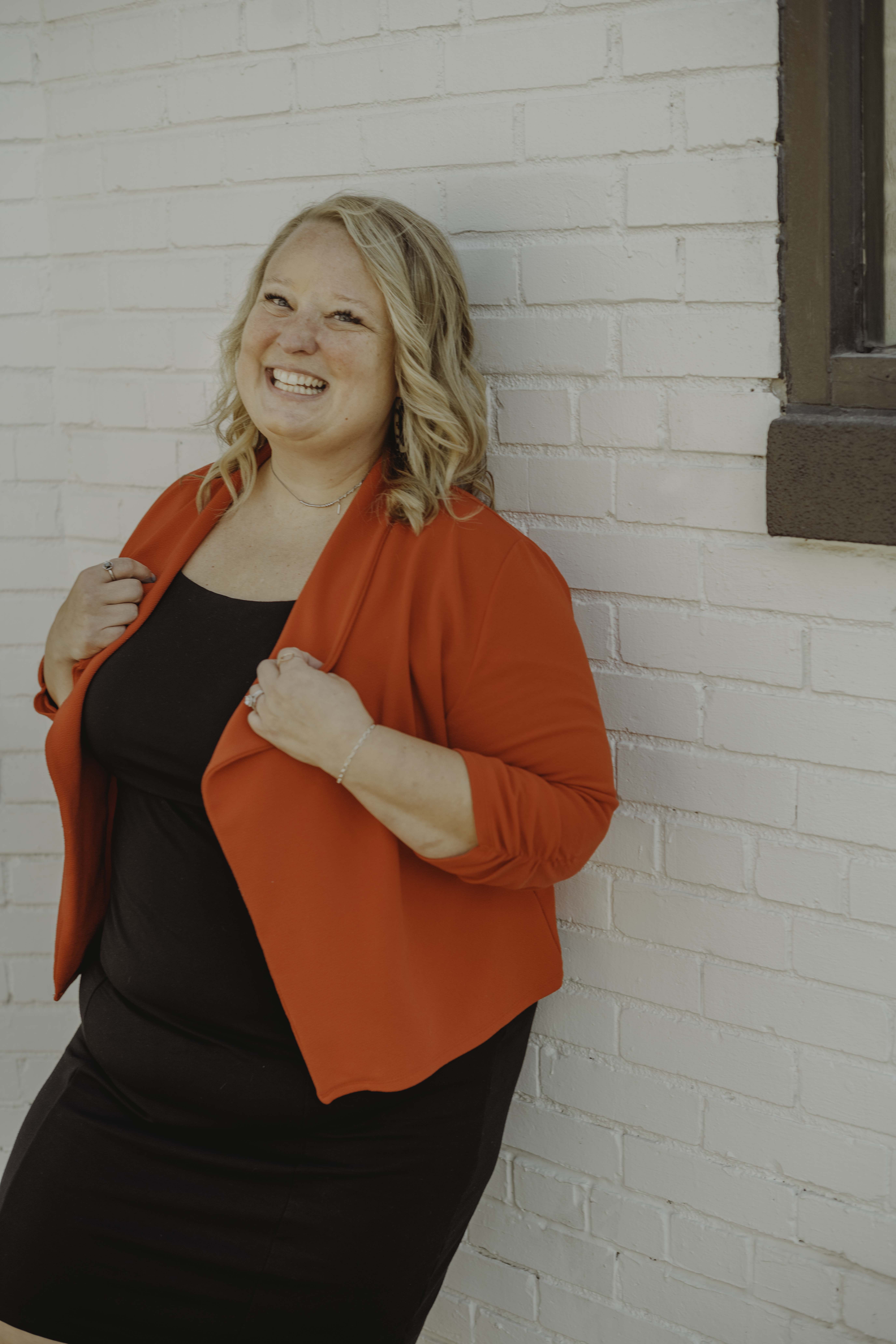 A cheerful student holds a tablet, smiling brightly