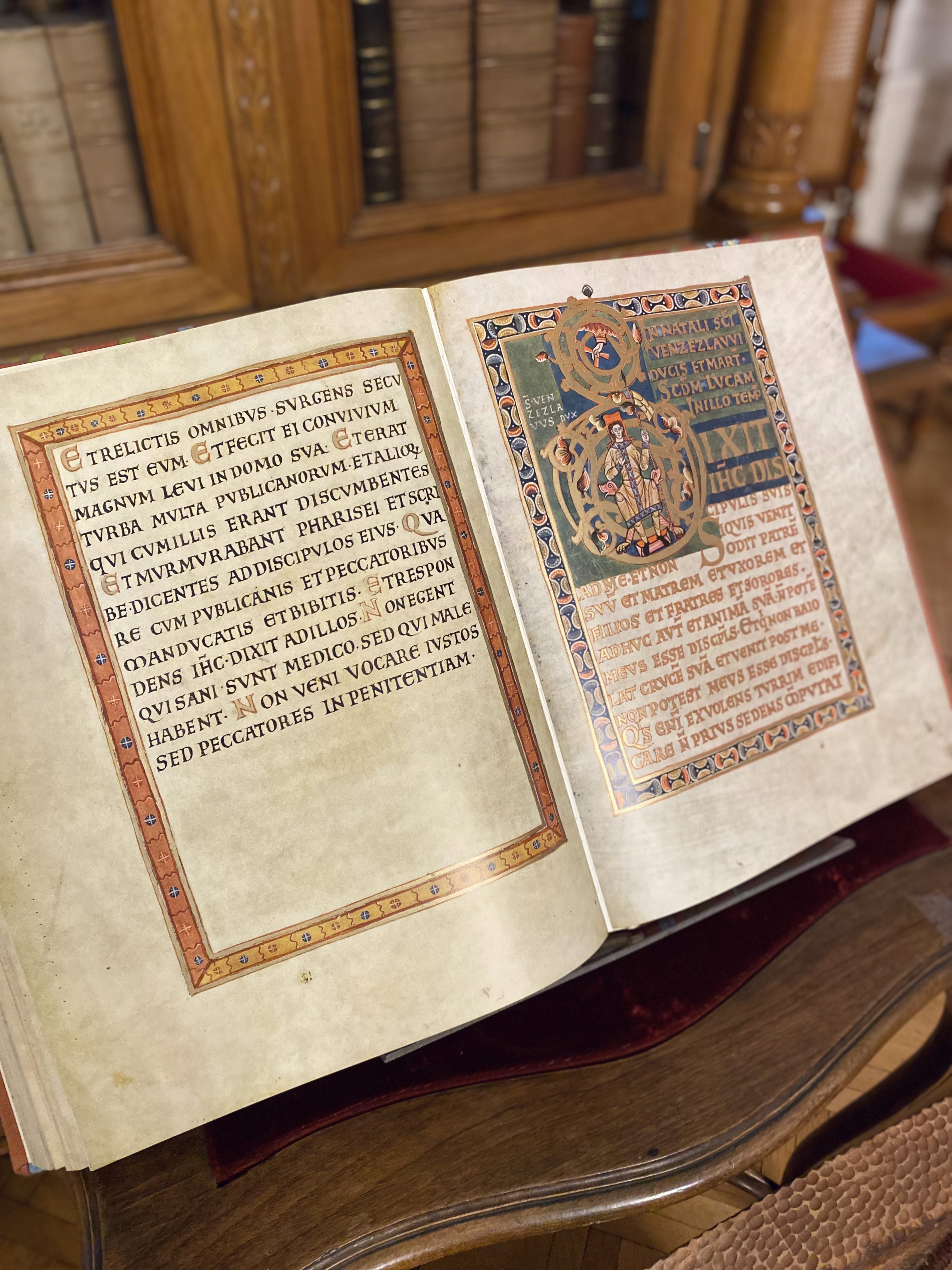 An old and ornate book stood on a plinth in the Archbishop's Palace in Olomouc, with gold hand-painted lettering