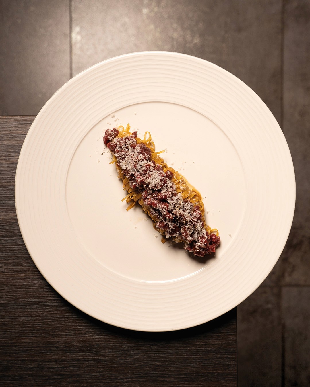„Frische Tagliolini mit fein gehobeltem Rindertatar und geriebenem Parmesan, serviert im Ristorante Giuseppe Gentile.“