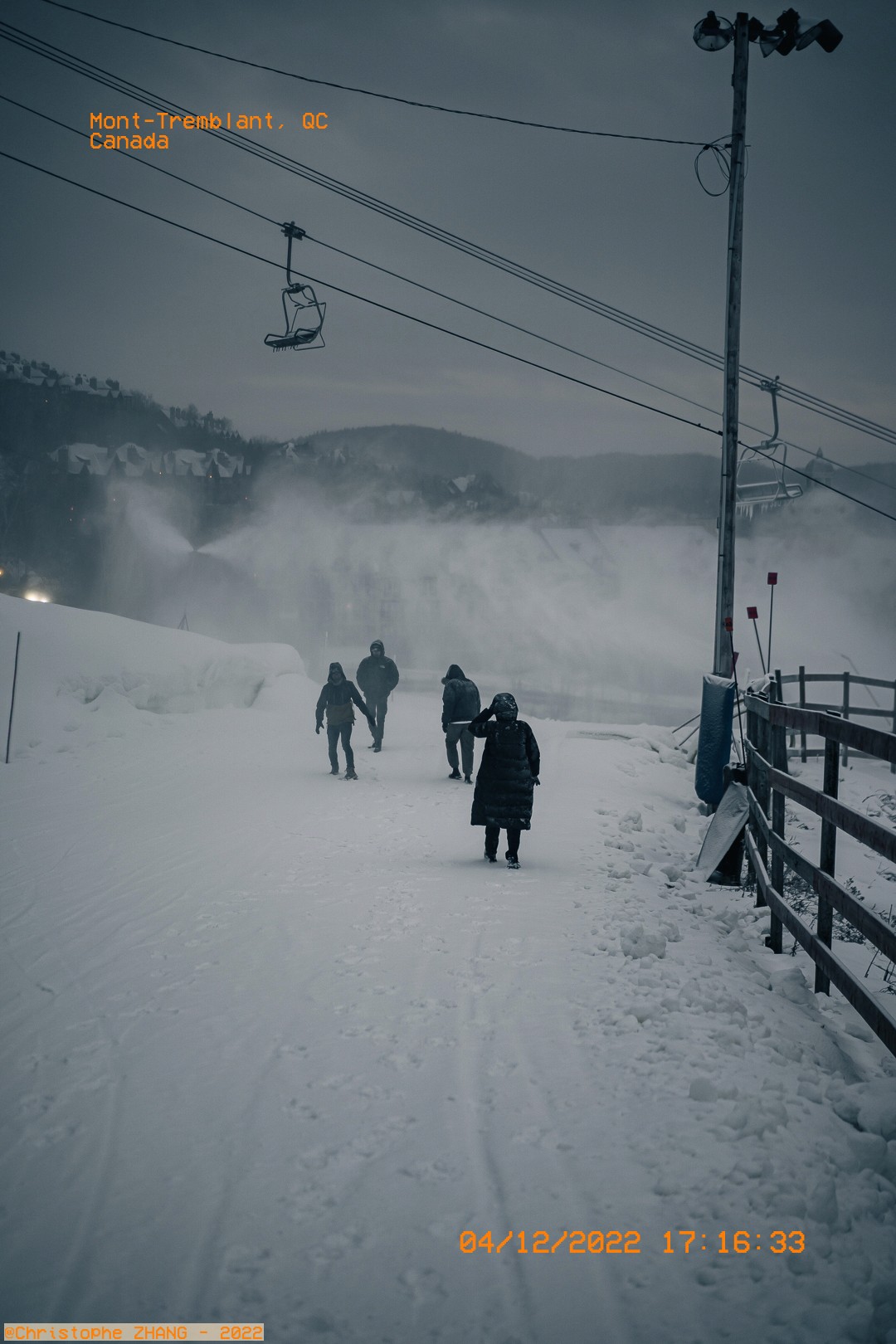 Groupe de marcheurs traversant une piste de ski enneigée au crépuscule à Mont-Tremblant.